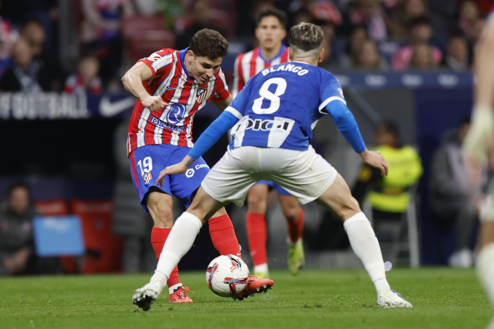 El delantero argentino del Atlético de Madrid Julián Álvarez lanza a puerta ante la oposición de Antonio Blanco, del Deportivo Alavés. EFE/ Javier Lizón