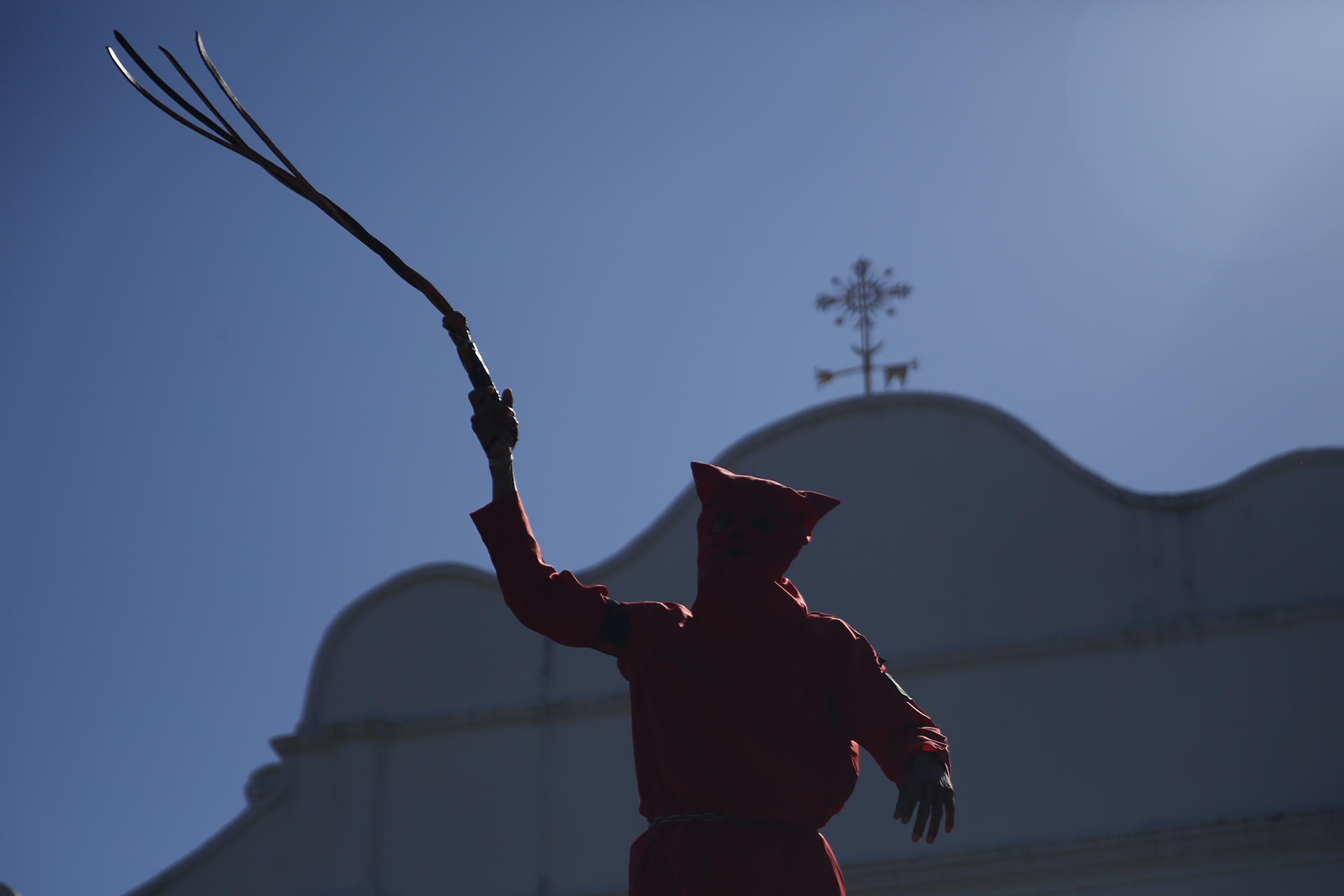 Un joven vestido como talcigüin, que en náhuatl significa hombre endiablado, al participar este lunes, 14 de abril, durante una celebración tradicional de la Semana Santa, en Texistepeque (El Salvador). EFE/Rodrigo Sura