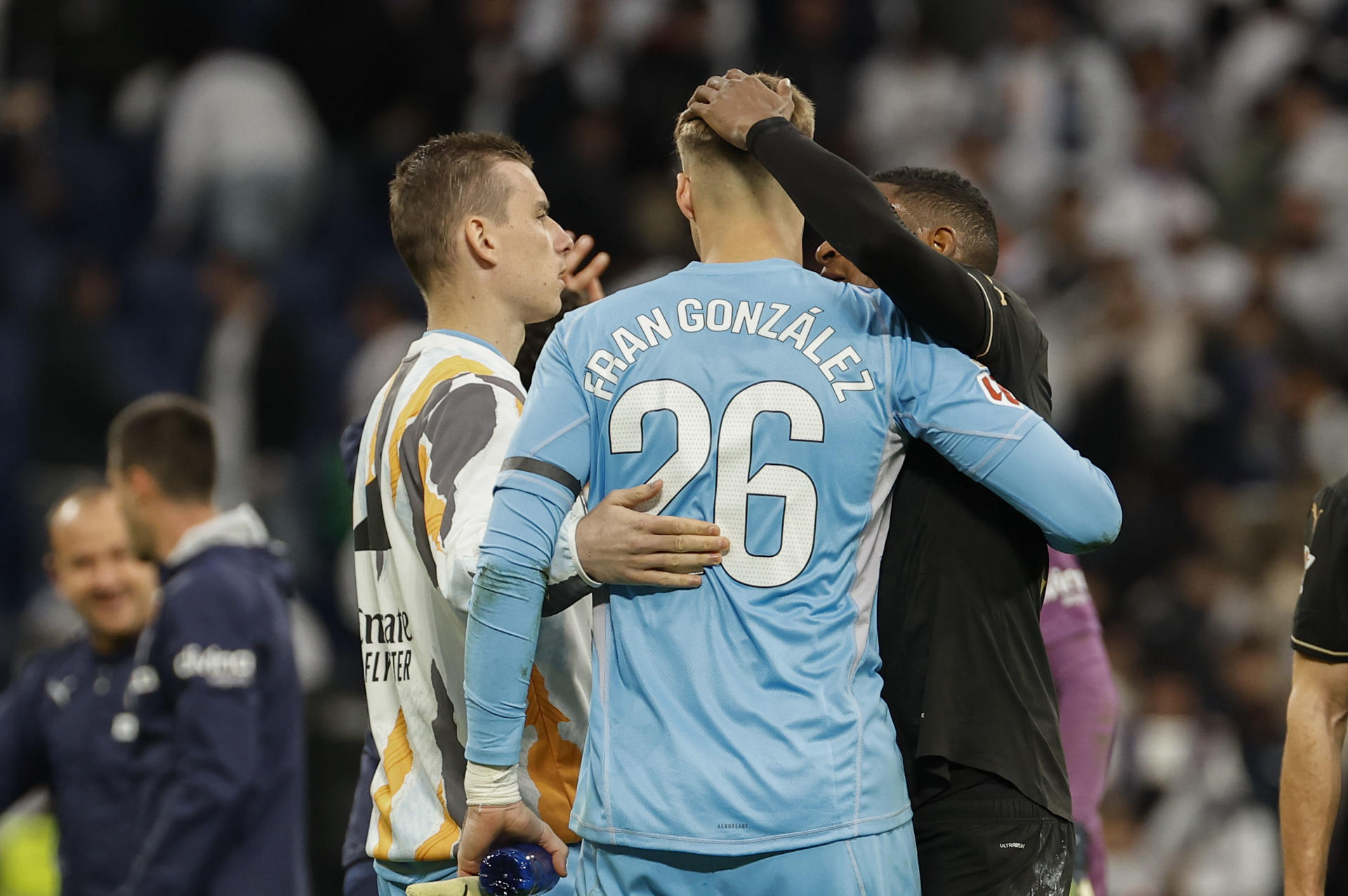 El portero del Real Madrid Lunin (I) anima al portero Fran Gonzalez (C) durante el partido de la jornada 30 entre el Real Madrid y el Valencia C.F. en el Santiago Bernabeu. EFE/Chema Moya