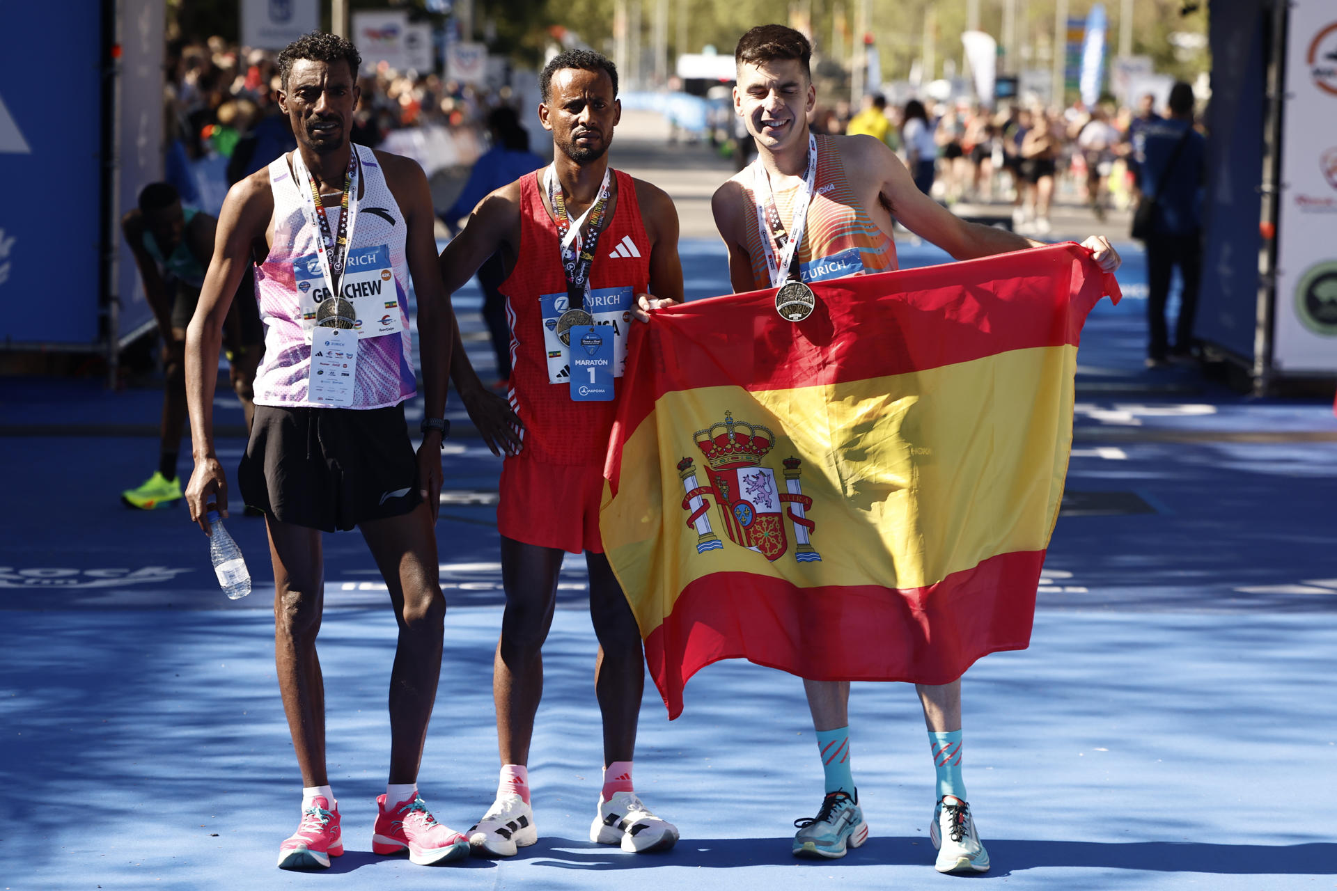 El etíope Derara Urisa (c) vencedor de la maratón de Madrid posa junto a su compatriota Limenih Getachew (i), segundo y el español Yago Rojo (d) tercero. EFE/ Sergio Pérez