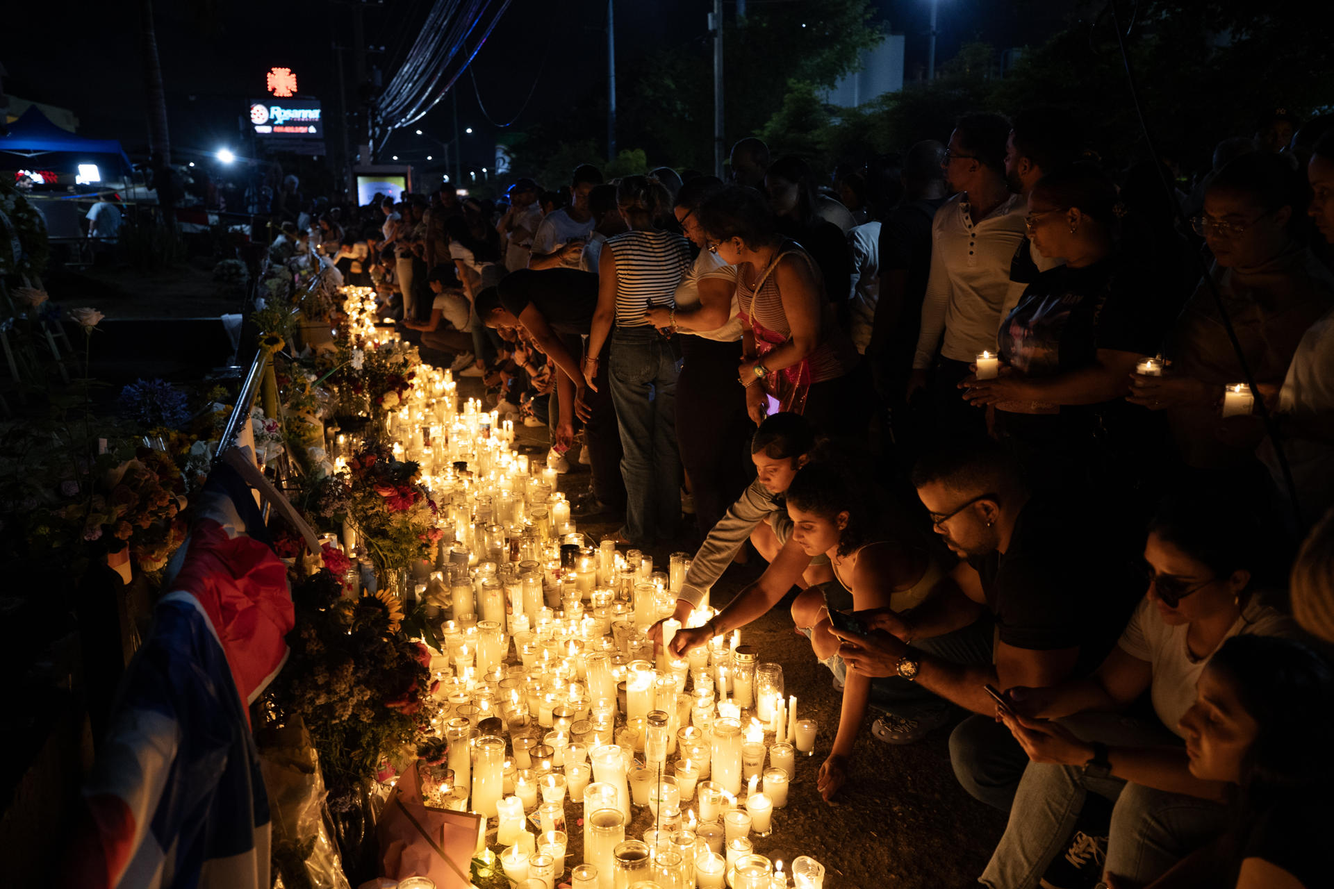 Fotografía del 12 de abril de varias personas durante un homenaje a los fallecidos en la discoteca Jet Set, en Santo Domingo (República Dominicana). EFE/Orlando Barría