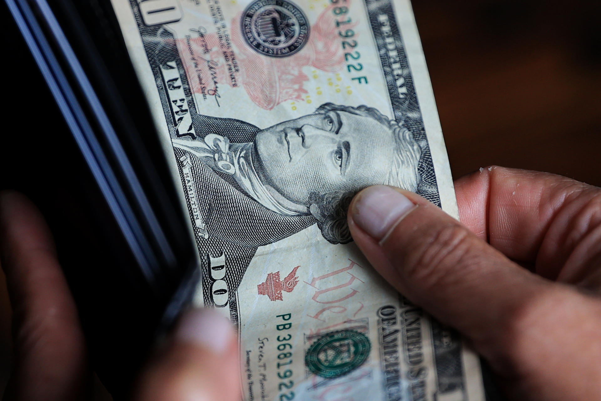 Una persona sostiene un billete de 10 dolares Quito (Ecuador). EFE/ José Jácome