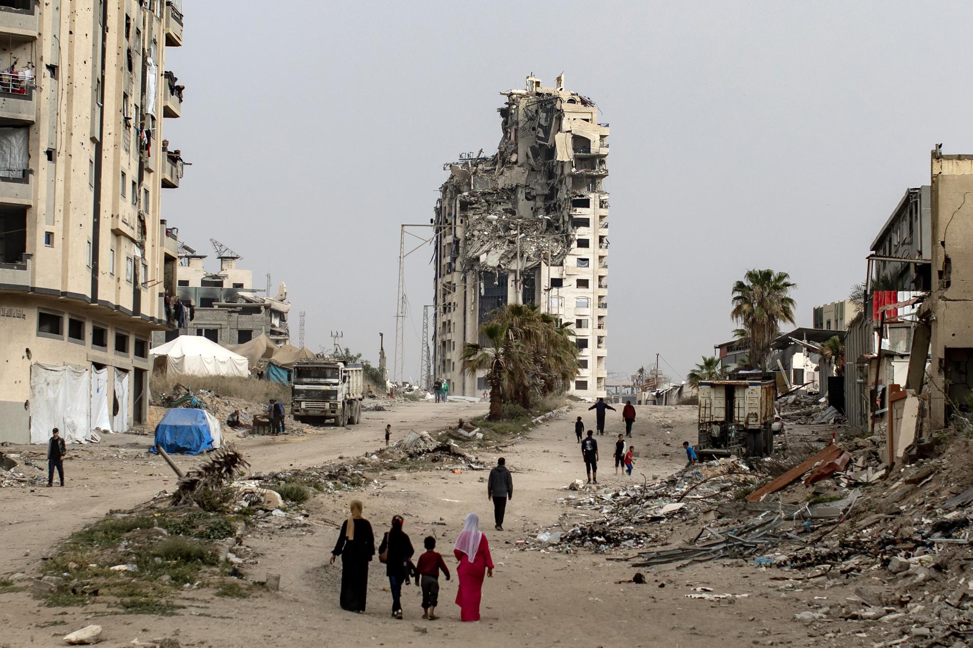 Palestinos desplazados internamente caminan junto a edificios destruidos en el oeste de la ciudad de Gaza, en la Franja de Gaza, 06 de abril de 2025.
EFE/EPA/HAITHAM IMAD