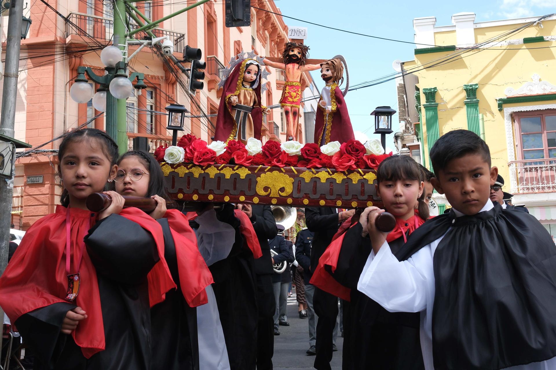 Niños sostienen una imagen de la crucifixión este Domingo de Ramos, en La Paz (Bolivia). EFE/ Luis Gandarillas