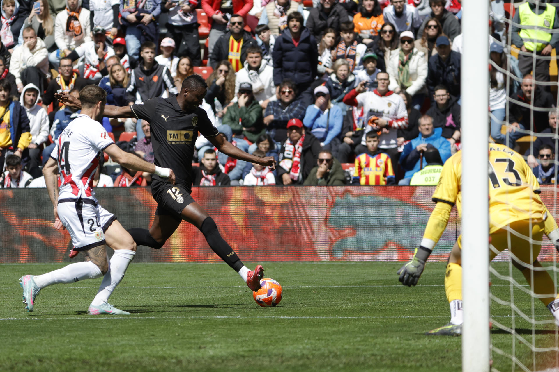 El jugador del Valencia CF Umar Sadiq (c) ante la portería de Augusto Batalla (d), del Rayo Vallecano, durante el partido de la jornada 32 de LaLiga EA Sports disputado este sábado en el estadio de Vallecas. EFE/Zipi Aragón