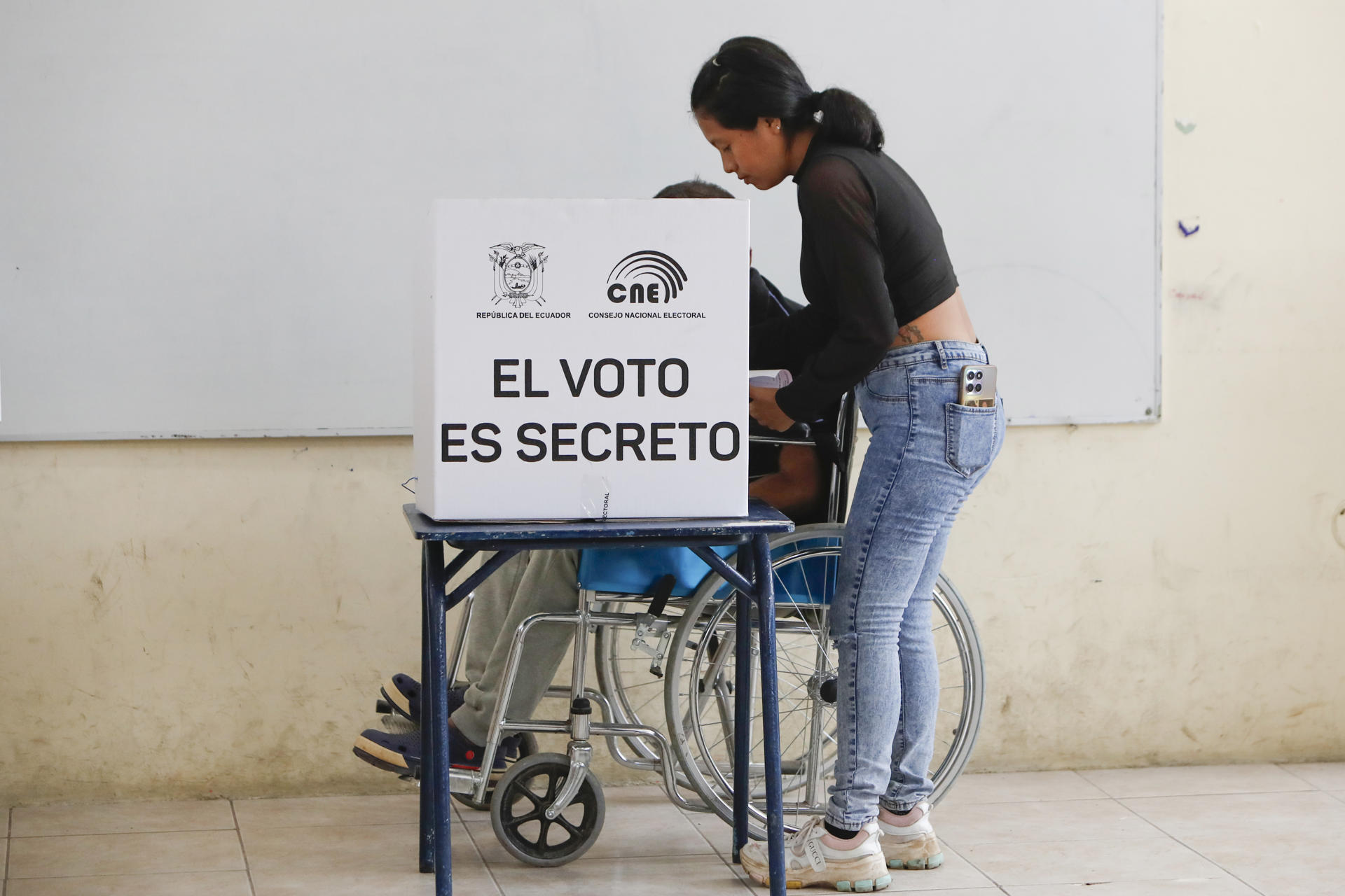 Un hombre en silla de ruedas marca su voto en un centro de votación este domingo, en Olón (Ecuador). EFE/ Carlos Durán Araújo