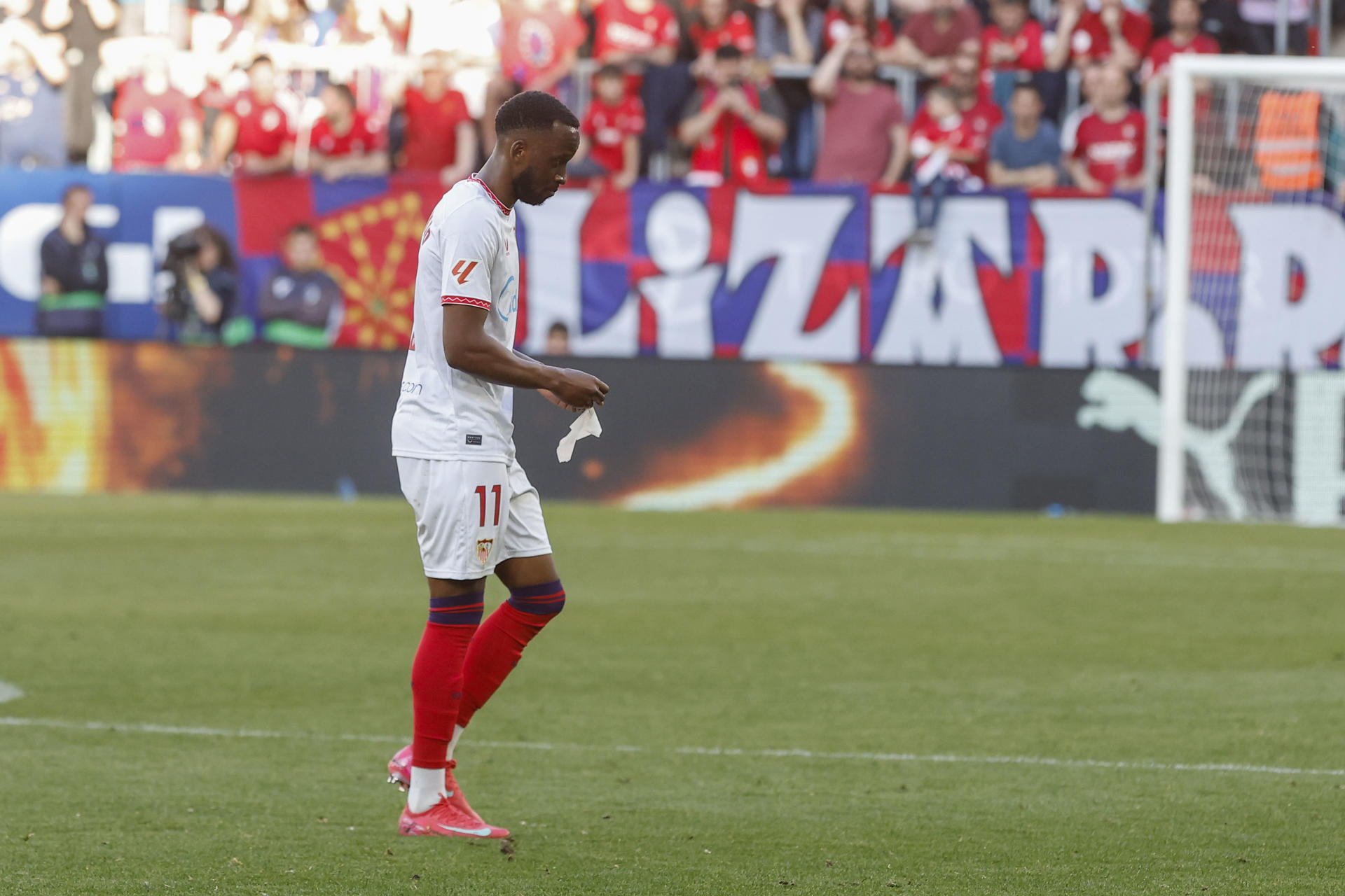 El extremo belga del Sevilla Dodi Lukébakio abandona el terreno de juego tras recibir tarjeta roj, durante el partido de la jornada 33 de LaLiga EA Sports, entre el Osasuna y el Sevilla, en el estadio El Sadar de Pamplona. EFE/ Villar López