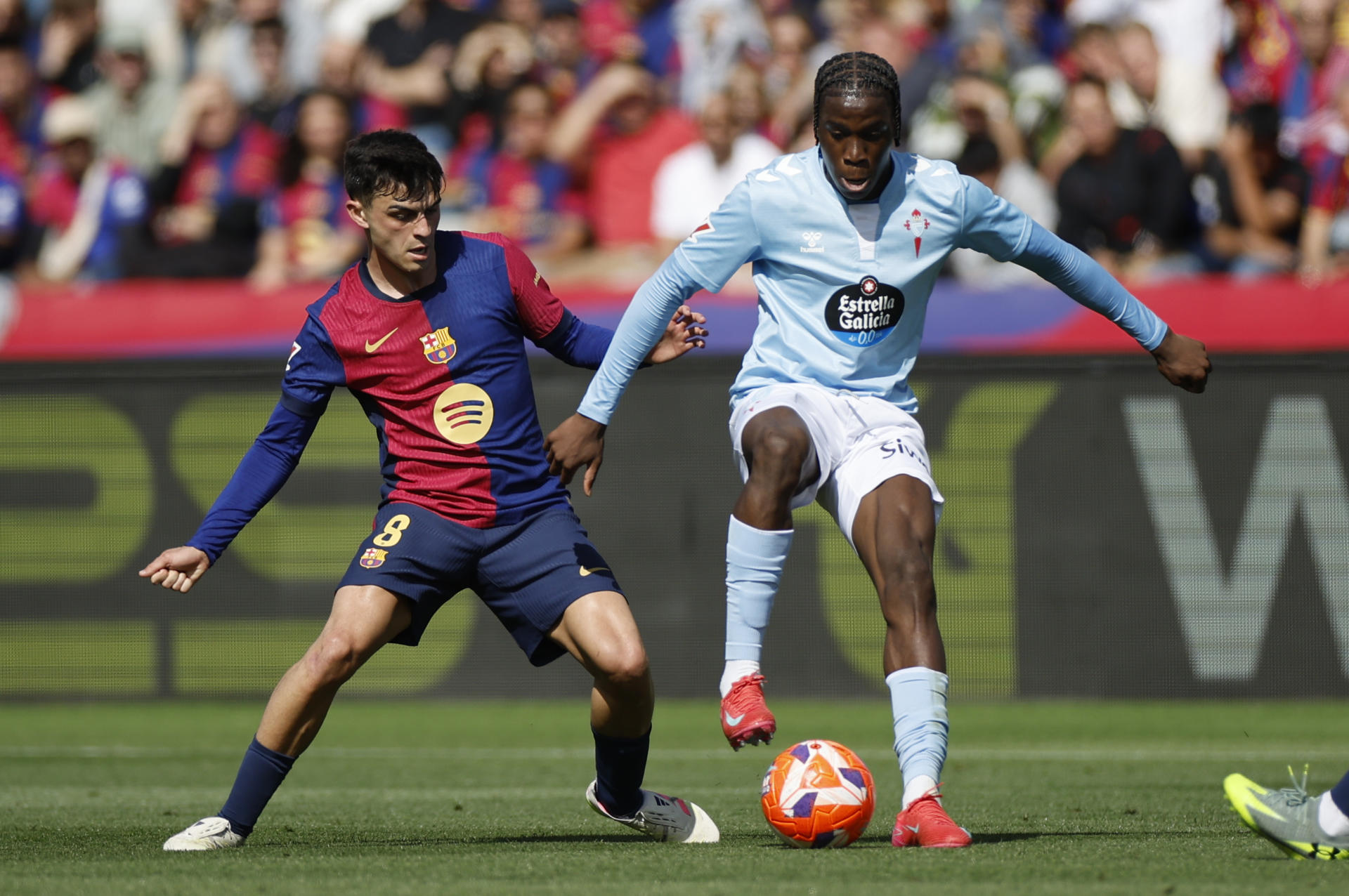 El centrocampista del Celta de Vigo Moriba Kourouma (d) cha por el balón con el centrocampista del FC Barcelona, Pedri durante el partido de la jornada 32 de LaLiga EA Sports que FC Barcelona y Celta de Vigo disputaron en el estadio olímpico Lluís Companys en Barcelona. EFE/ Alberto Estevez