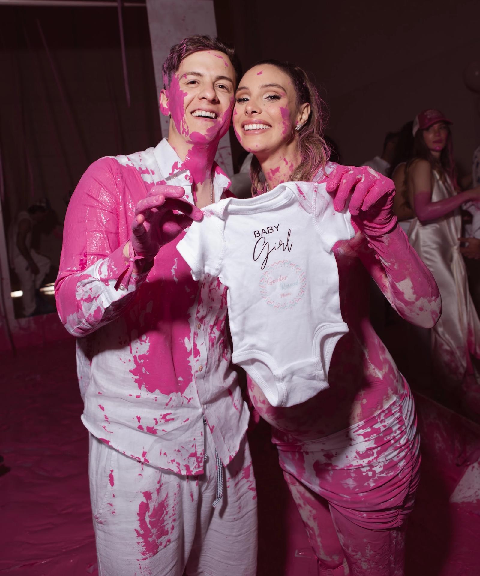 Fotografía cedida por EB Public Relations donde aparece la venezolana Lele Pons y el puertorriqueño Guaynaa manchados de color rosa y sosteniendo un vestido infantil de niñas durante la fiesta de revelación del sexo de su bebé celebrada este viernes en el Faena Forum en Miami, Florida (EE.UU.). EFE/EB Public Relations /SOLO USO EDITORIAL /NO VENTAS /SOLO DISPONIBLE PARA ILUSTRAR LA NOTICIA QUE ACOMPAÑA /CRÉDITO OBLIGATORIO
