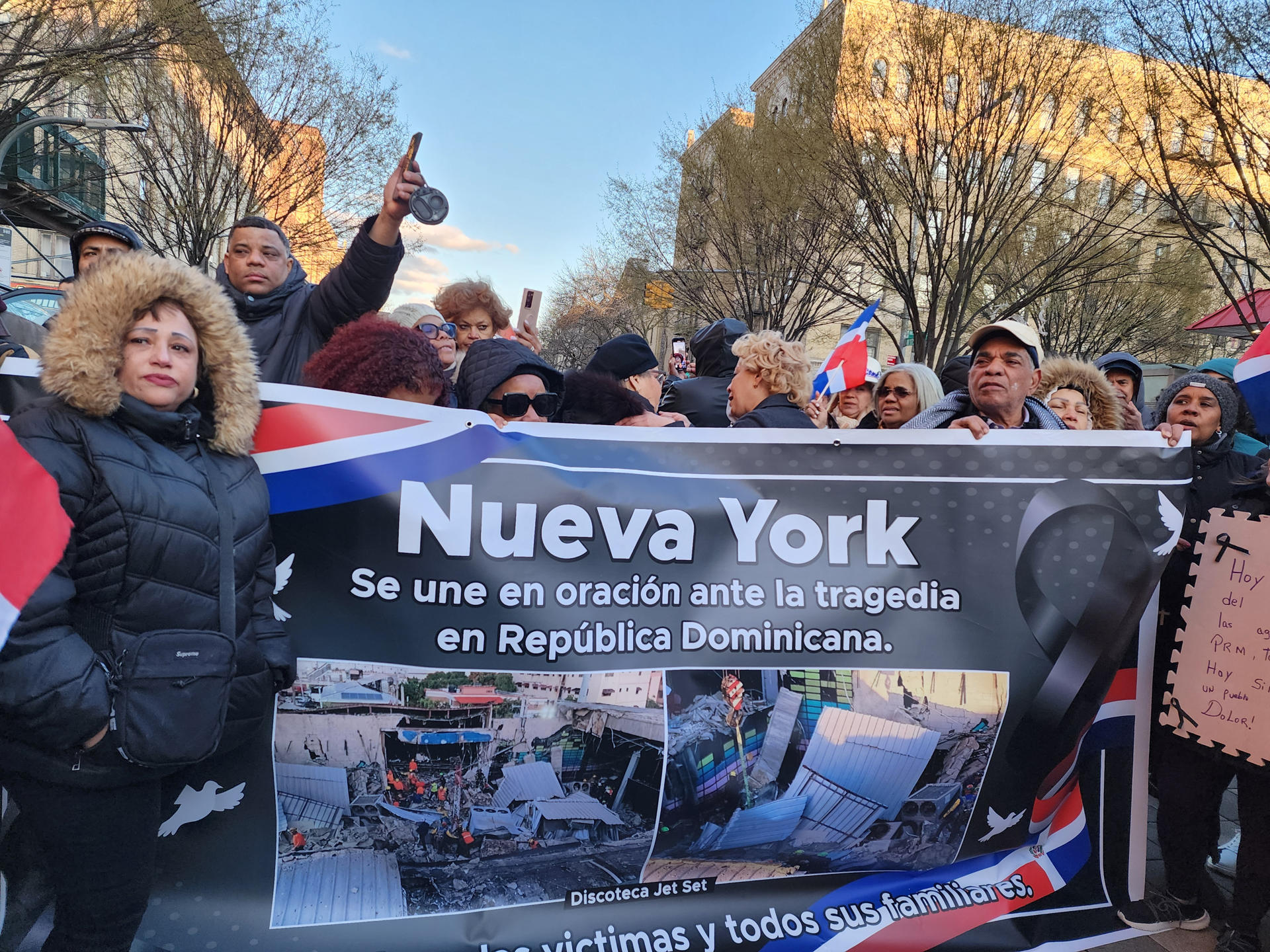 Un grupo de personas sostiene un cartel durante una vigilia por las victimas del accidente en una discoteca de Santo Domingo este martes, en Nueva York (Estados Unidos). EFE/ Ruth Hernández