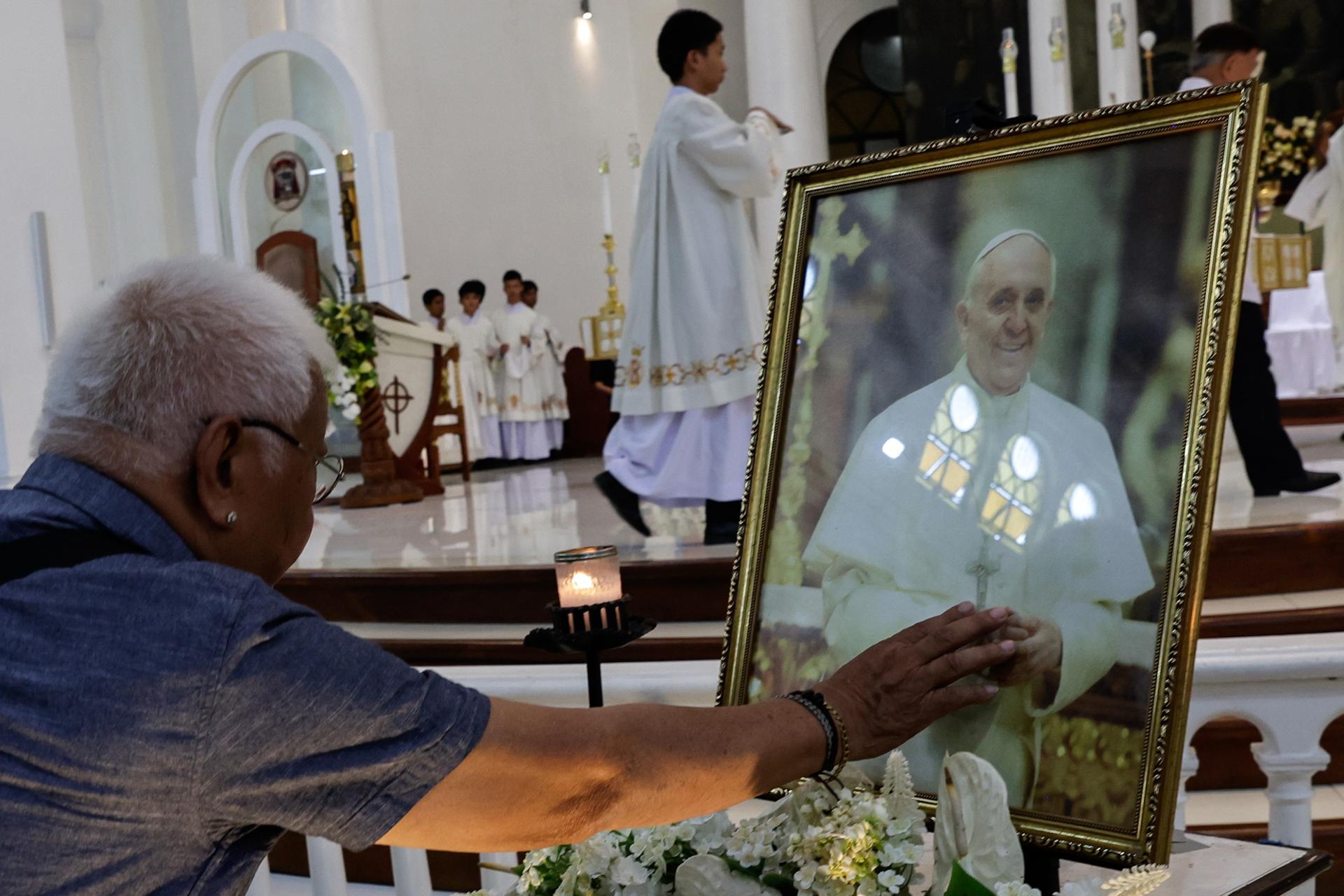 Fotografía de archivo, tomada el 22/04/2025, que muestra a un fiel católico de Filiípinas tocando un cuadro del papa Francisco durante una misa en Manila por la muerte del pontífice argentino. (Papa, Santa Sede, Filipinas, Caloocan) EFE/EPA/ROLEX DELA PENA