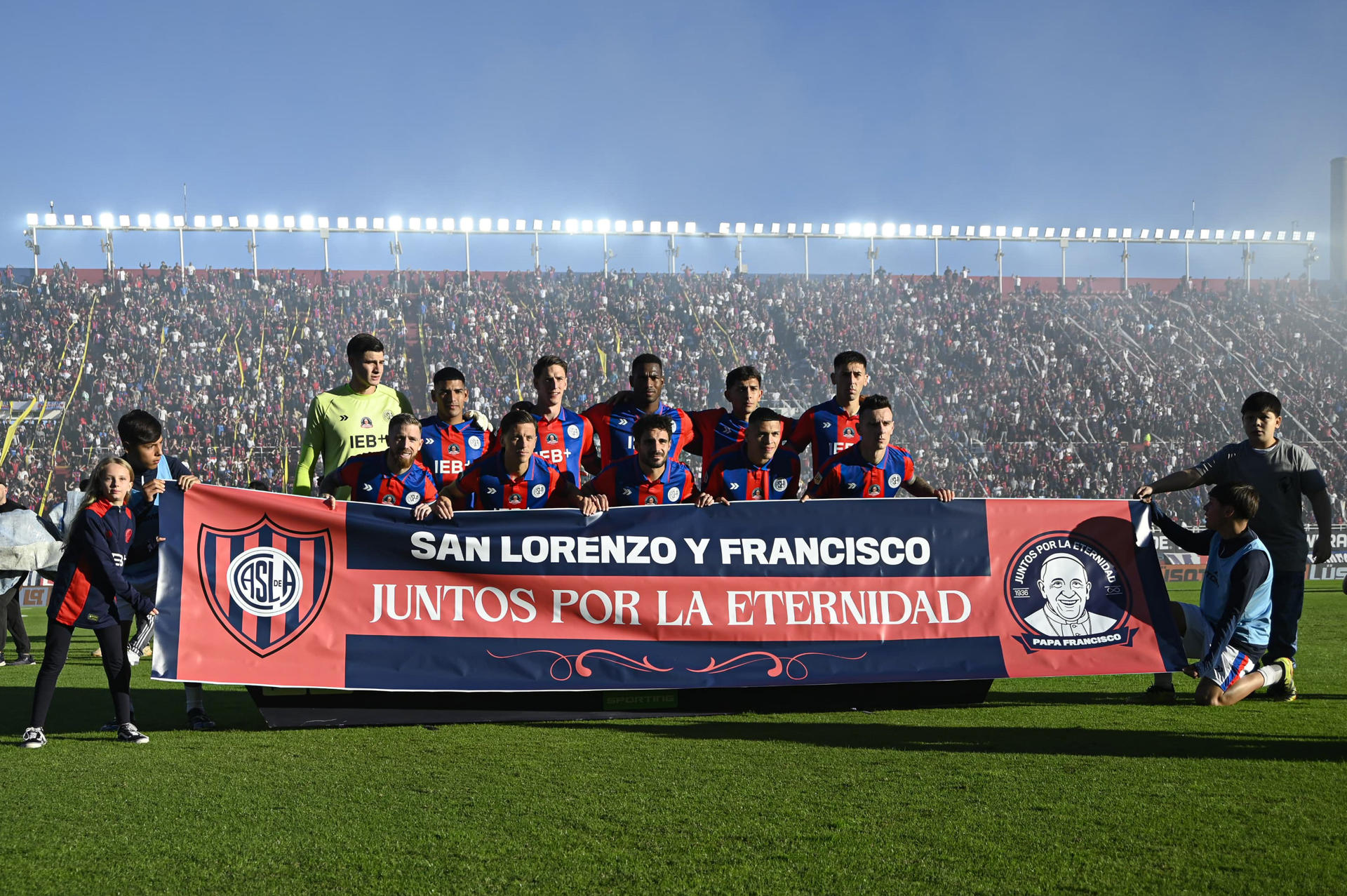 Jugadores de San Lorenzo de Almagro forman con un cartel en homenaje al papa Francisco previo a un partido frente a Rosario Central en Buenos Aires (Argentina). EFE/ Stringer