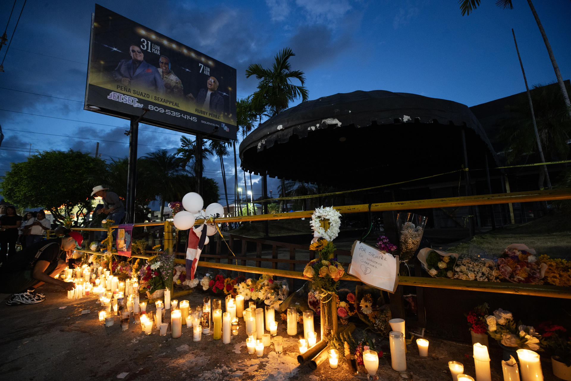Fotografía de flores y velas encendidas a las afueras de la discoteca Jet Set este viernes, en Santo Domingo (República Dominicana). EFE/Orlando Barría