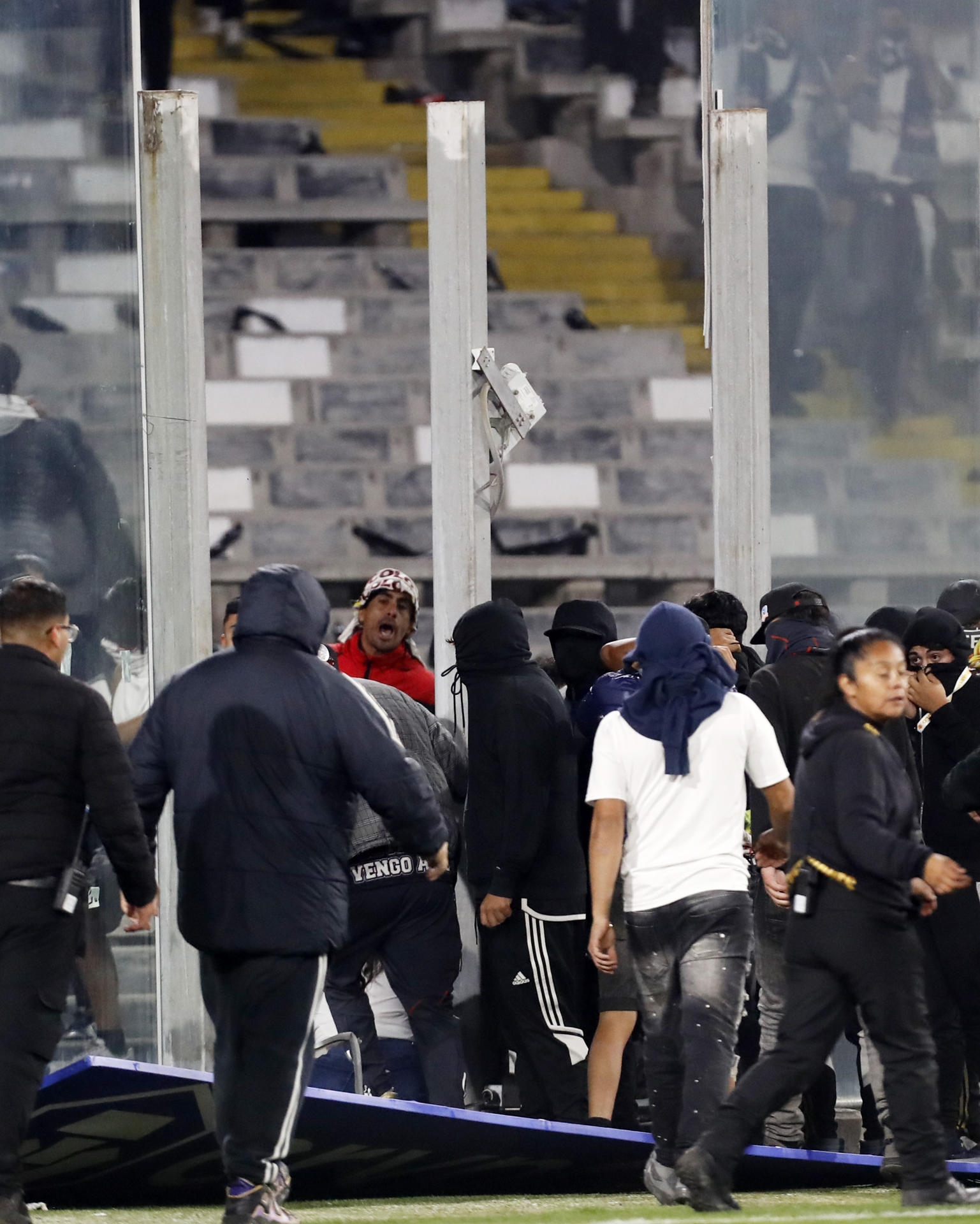 Aficionados de Colo Colo invaden el campo de juego después de la muerte de dos hinchas asfixiados por una avalancha tras una carga policial en un partido de la fase de grupos de la Copa Libertadores entre Colo Colo y Fortaleza en el estadio Monumental David Arellano, en Santiago (Chile). EFE/ Osvaldo Villarroel