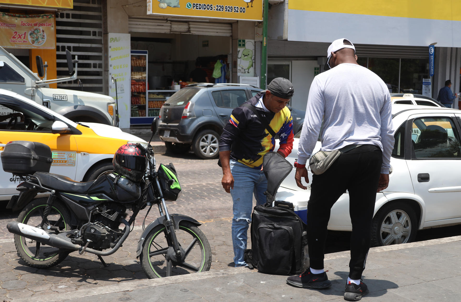 Un migrante ofrece alimentos y productos a una persona este viernes en el municipio de Tuxtla Gutiérrez en el estado de Chiapas (México). EFE/Carlos López
