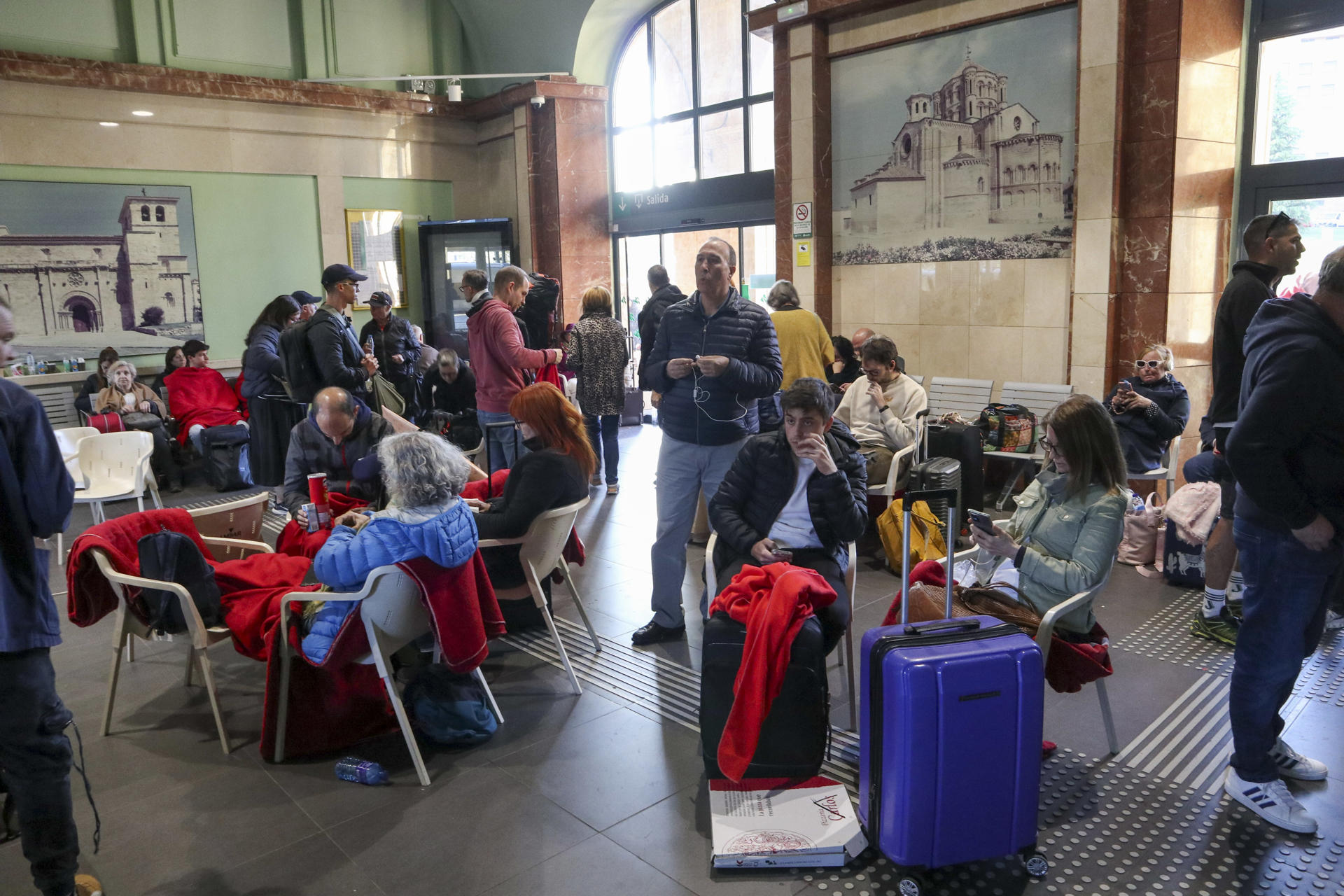 Los pasajeros del tren que el apagón dejó tirados en Zamora y que han pasado la noche en la estación de Renfe ya están siendo trasladado en autobuses a sus destinos este martes. EFE/Mariam A. Montesinos