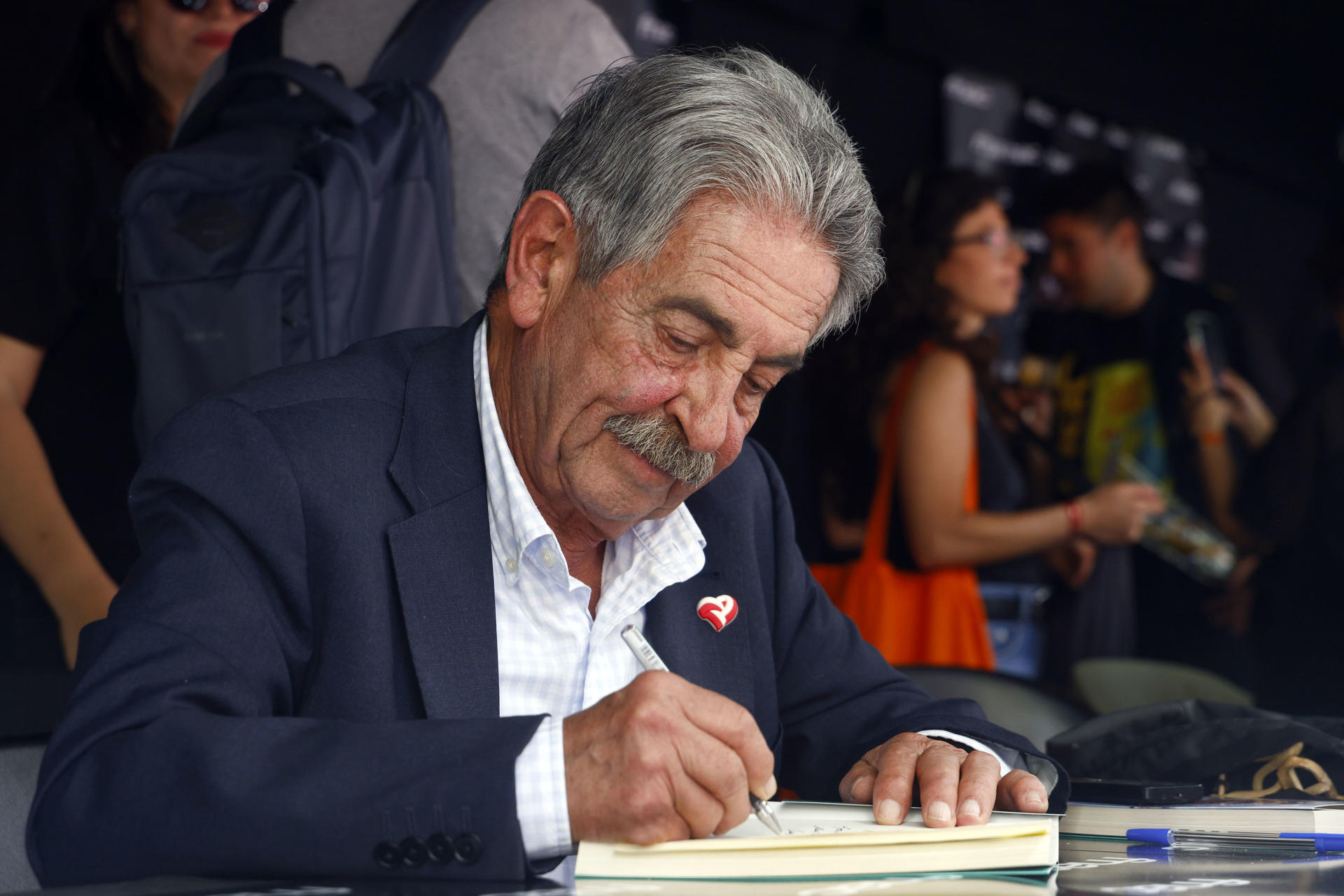 El expresidente de Cantabria Miguel Ángel Revilla firma libros durante la Diada de Sant Jordi, en la que los catalanes toman las calles a la búsqueda de libros y rosas para regalar a sus seres queridos y allegados. EFE/Quique García