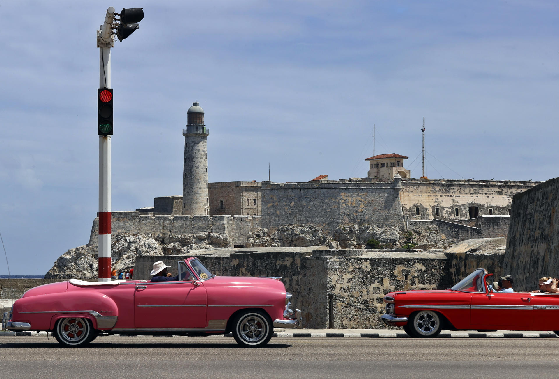 Turistas pasean en un auto clásico frente al Castillo del Morro este viernes, en una calle de La Habana (Cuba). EFE/ Ernesto Mastrascusa