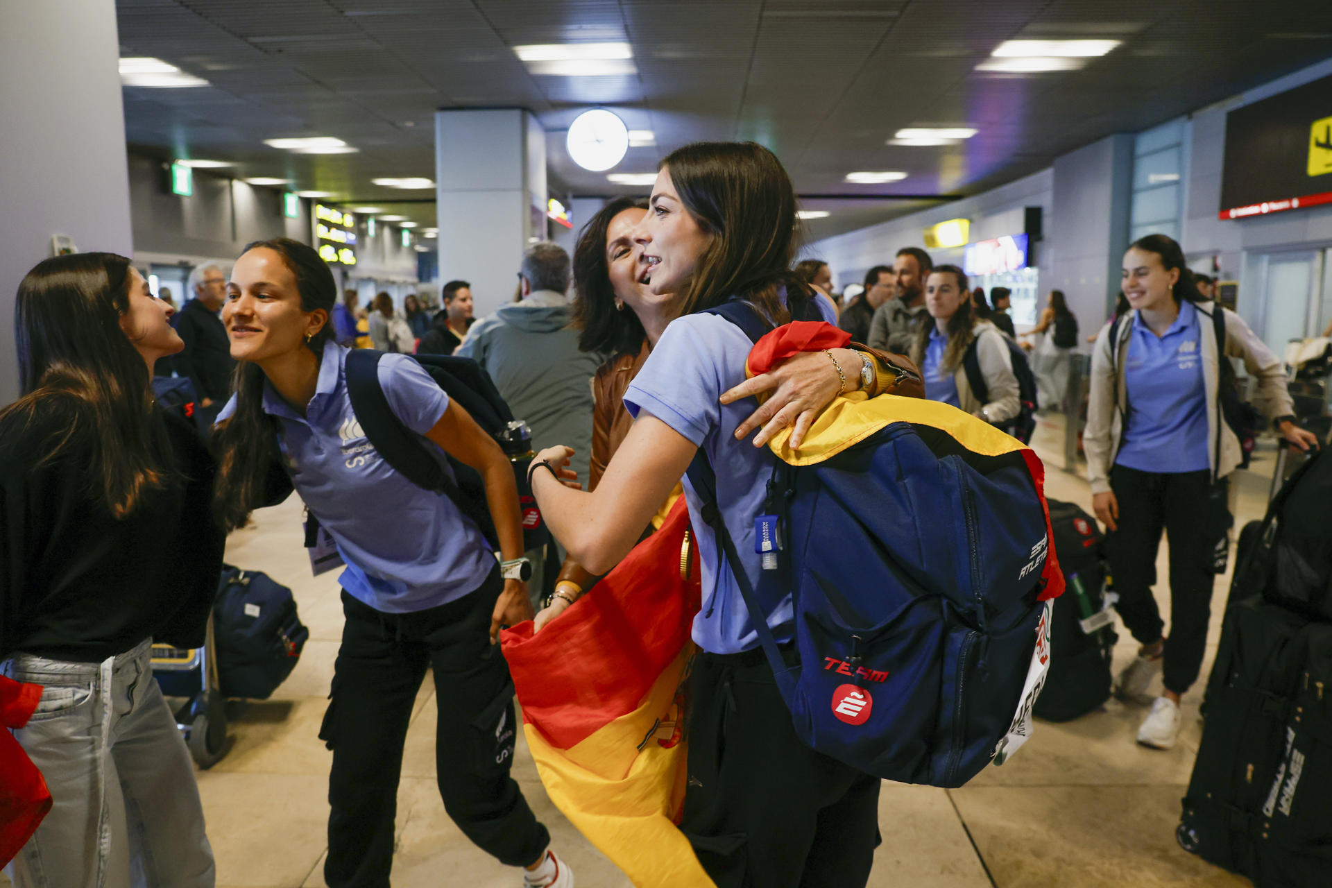 La atleta Blanca Hervás (d), una de las componentes del equipo femenino de relevos 4x400m que ganó el oro en el Mundial de Guangzhou, es recibida a la llegada de los atletas participantes en el Mundial, al Aeropuerto Internacional Adolfo Suárez Madrid-Barajas. EFE/ Javier Lizón