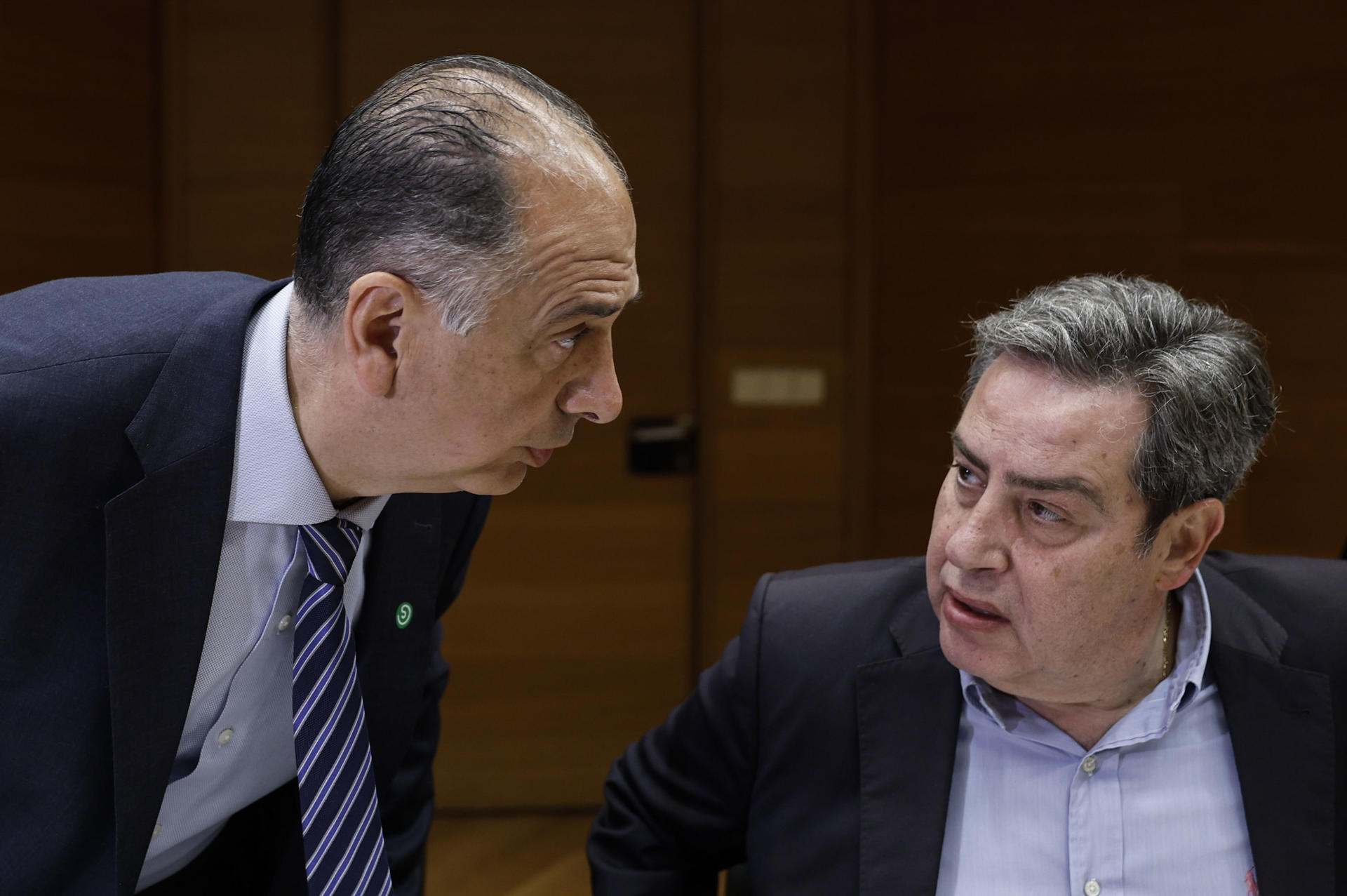 El conseller de Emergencias e Interior, Juan Carlos Valderrama, comparece ante la Comisión de Justicia, Gobernación y Administración Local de Les Corts Valencianes para informar de las decisiones adoptadas tras la dana del 29 de octubre, a petición del PSPV-PSOE, Compromís y Vox. En la imagen, Valderrama charla con el presidente de la comisión, el diputado de Vox José María Llanos. EFE/Biel Aliño