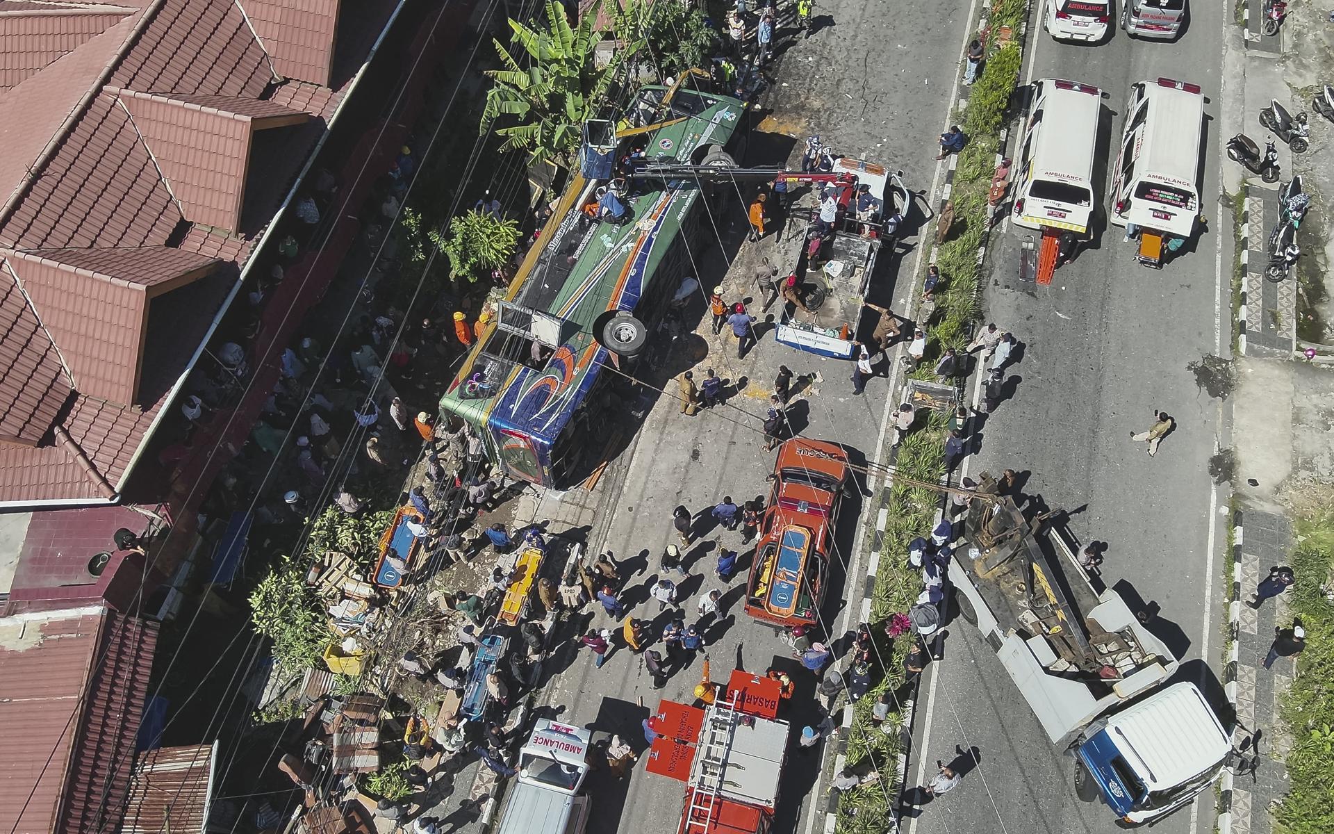 PADANG PANJANG (Indonesia), 06/05/2025.- A handout photo made available by the Indonesia's Search and Rescue Agency (BASARNAS) shows rescuers working on an overturned bus after a crash in Padang Panjang, West Sumatra, Indonesia, 06 May 2025. At least 12 people were killed and dozens injured following the accident, according to the police. EFE/EPA/BASARNAS HANDOUT HANDOUT EDITORIAL USE ONLY/NO SALES