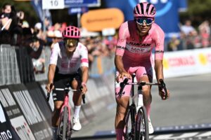 El ciclista mexicano Isaac Del Toro (d), del UAE Team Emirates XRG, con el maillot rosa de líder de la general, y el ciclista ecuatoriano Richard Carapaz, del equipo Education - Easypost, reaccionan después de cruzar la línea de meta durante la 19ª etapa del Giro d'Italia en Champoluc (Italia). EFE/LUCA ZENNARO