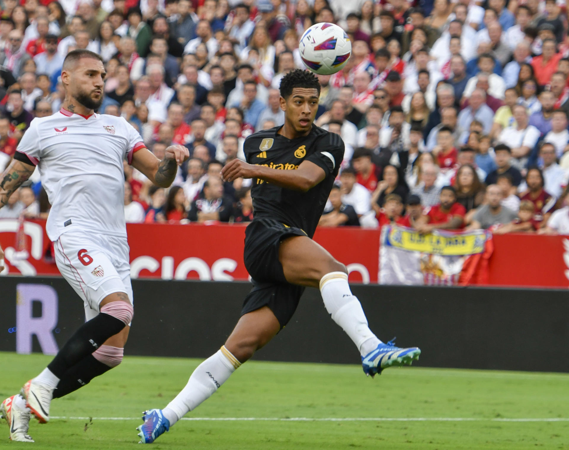 El delantero del Real Madrid Jude Bellingham (d) remata un balón ante Nemanja Gudelj, del Sevilla, durante un partido en el estadio Ramón Sánchez Pizjuán en foto de archivo de Raúl Caro. EFE