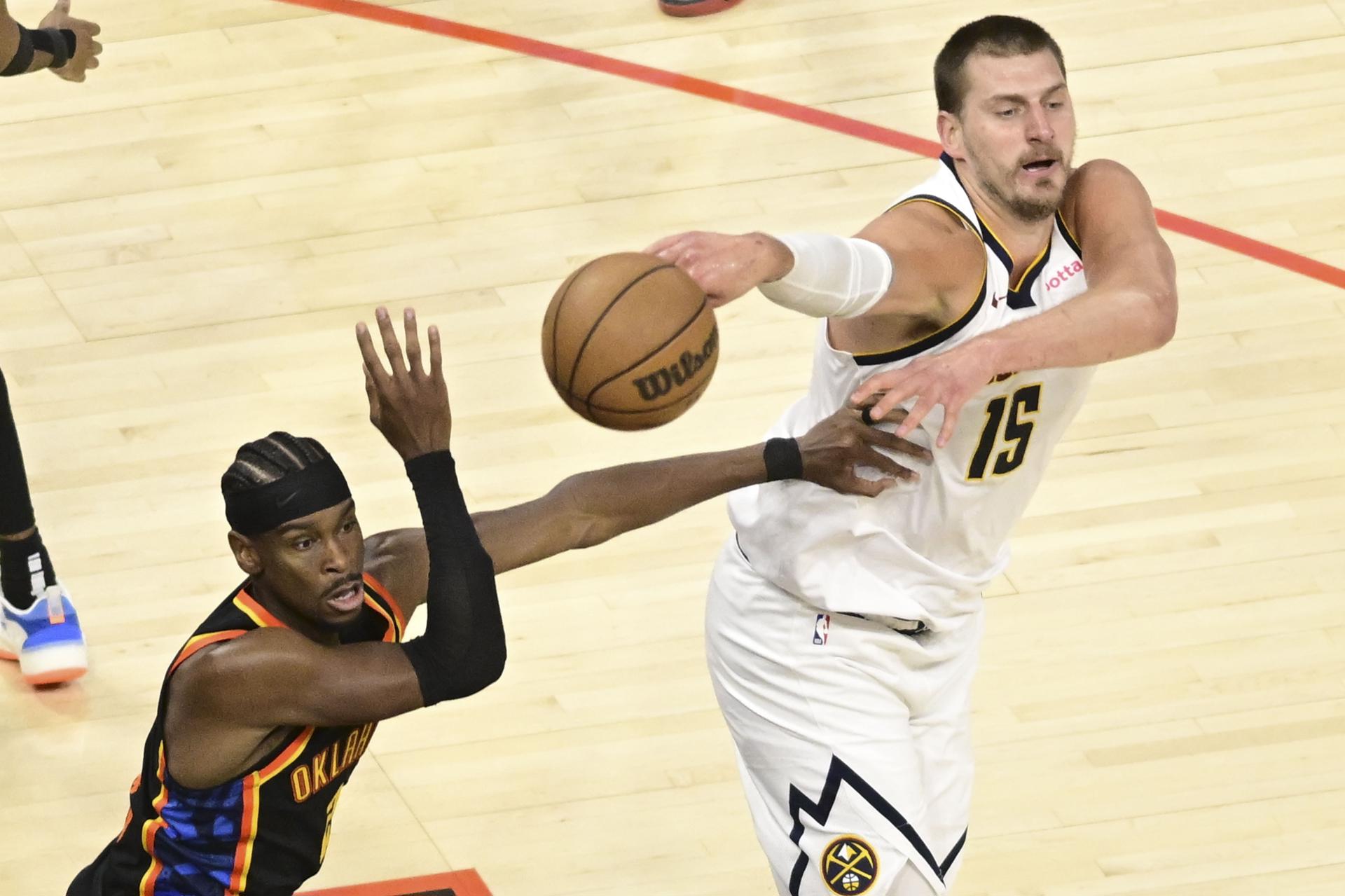 El pívot serbio Nikola Jokic (d), de los Denver Nuggets, pasa el balón ante el base de Oklahoma City Thunder Shai Gilgeous-Alexander en el segundo partido de las semifinales de la Conferencia Oeste que ganaron los Thunder. EFE/EPA/GERALD LEONG SHUTTERSTOCK OUT
