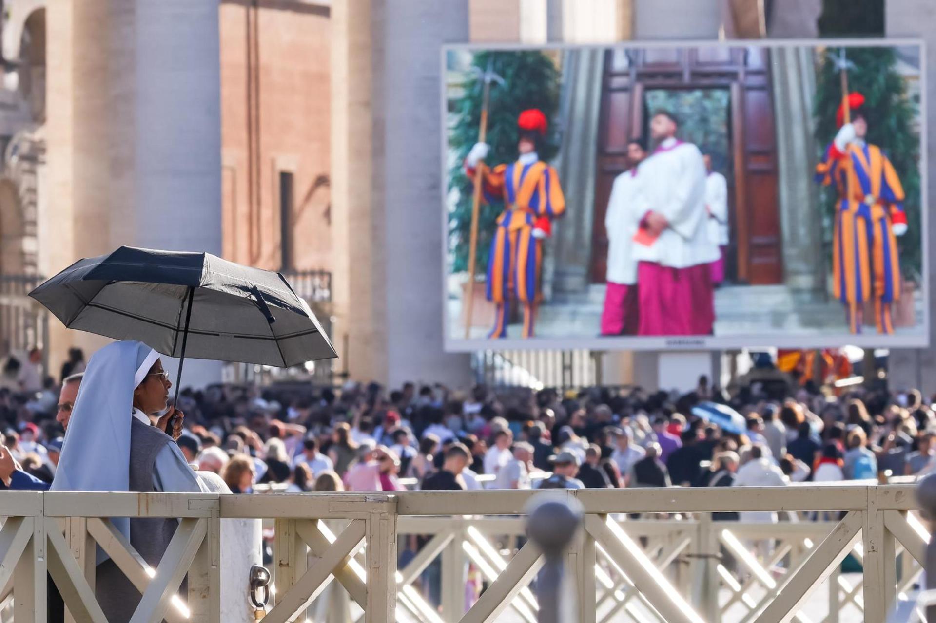 Fieles observan una pantalla gigante que muestra imágenes de la procesión de cardenales a la capilla Sixtina cuando comienza el cónclave para elegir un nuevo Papa, en la Plaza de San Pedro en El Vaticano, 07 de mayo de 2025. Las medidas de seguridad en la Ciudad del Vaticano han incluido el 'blindaje' de la red móvil y los datos en todo el Estado de la Ciudad, para evitar que los cardenales electores entren en contacto con el mundo exterior y, por lo tanto, asegurar que no haya influencia en el voto. (Papa, Cardenal) EFE/EPA/ANDREA SOLERO