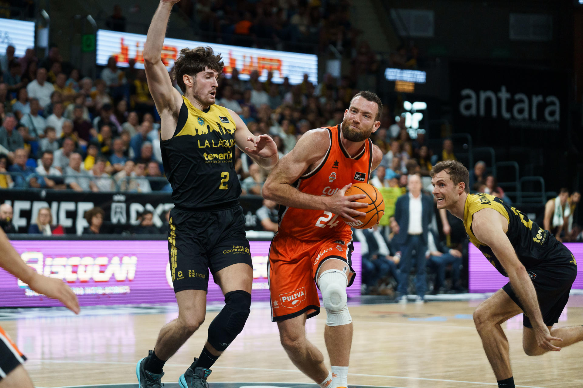 El pívot del Valencia Basket Matt Costello (c) y el alero de La Laguna Tenerife Kostas Kostadinov (i) durante el partido de la jornada 33 de la Liga Endesa, que se disputó este domingo en el pabellón Santiago Martín de La Laguna (Tenerife) EFE/Ramón de la Rocha