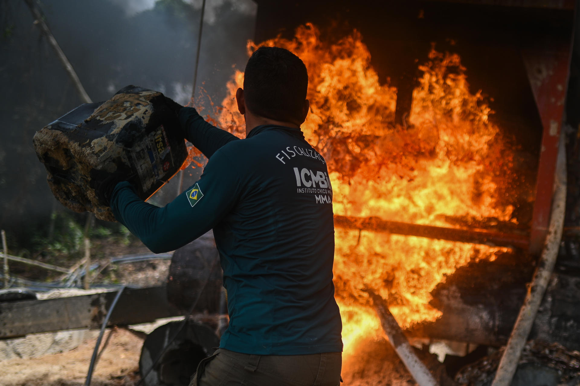 Fotografía de archivo del 14 de febrero de 2023 de un agente ambiental federal lanzando combustible a equipos utilizados para minería ilegal durante un operativo del Instituto Chico Mendes (ICMBio), en la Floresta Ambiental de Altamira, estado de Pará (Brasil). EFE/ Andre Borges