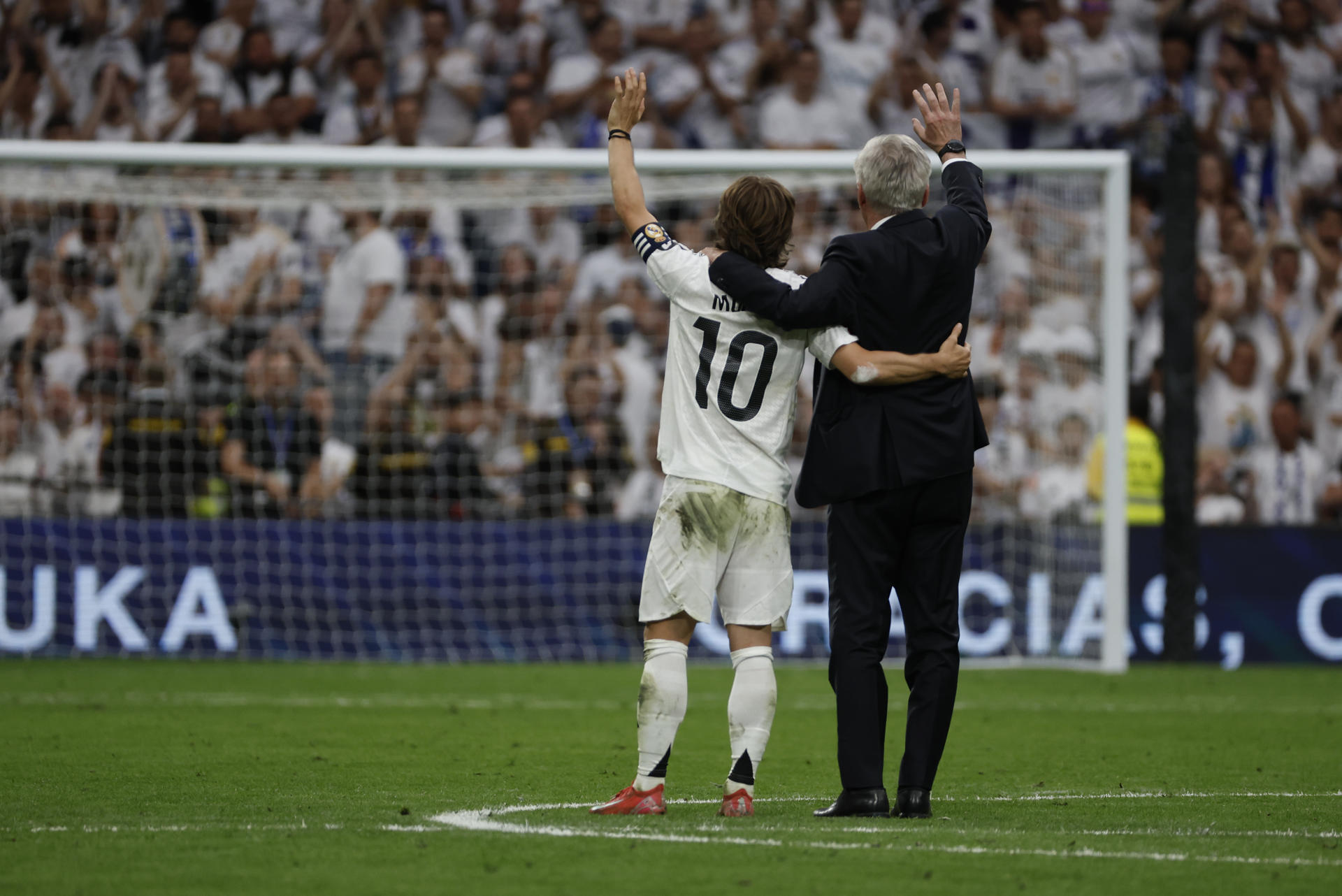 El entrenador del Real Madrid, Carlo Ancelotti (d), y el centrocampista croata Luka Modrić (i) reciben un homenaje tras su último partido en el Santiago Bernabéu al término del encuentro de la jornada 38 de LaLiga EA Sports entre Real Madrid y Real Sociedad celebrado este sábado en el estadio Santiago Bernabéu de Madrid. EFE/ J.J.Guillén