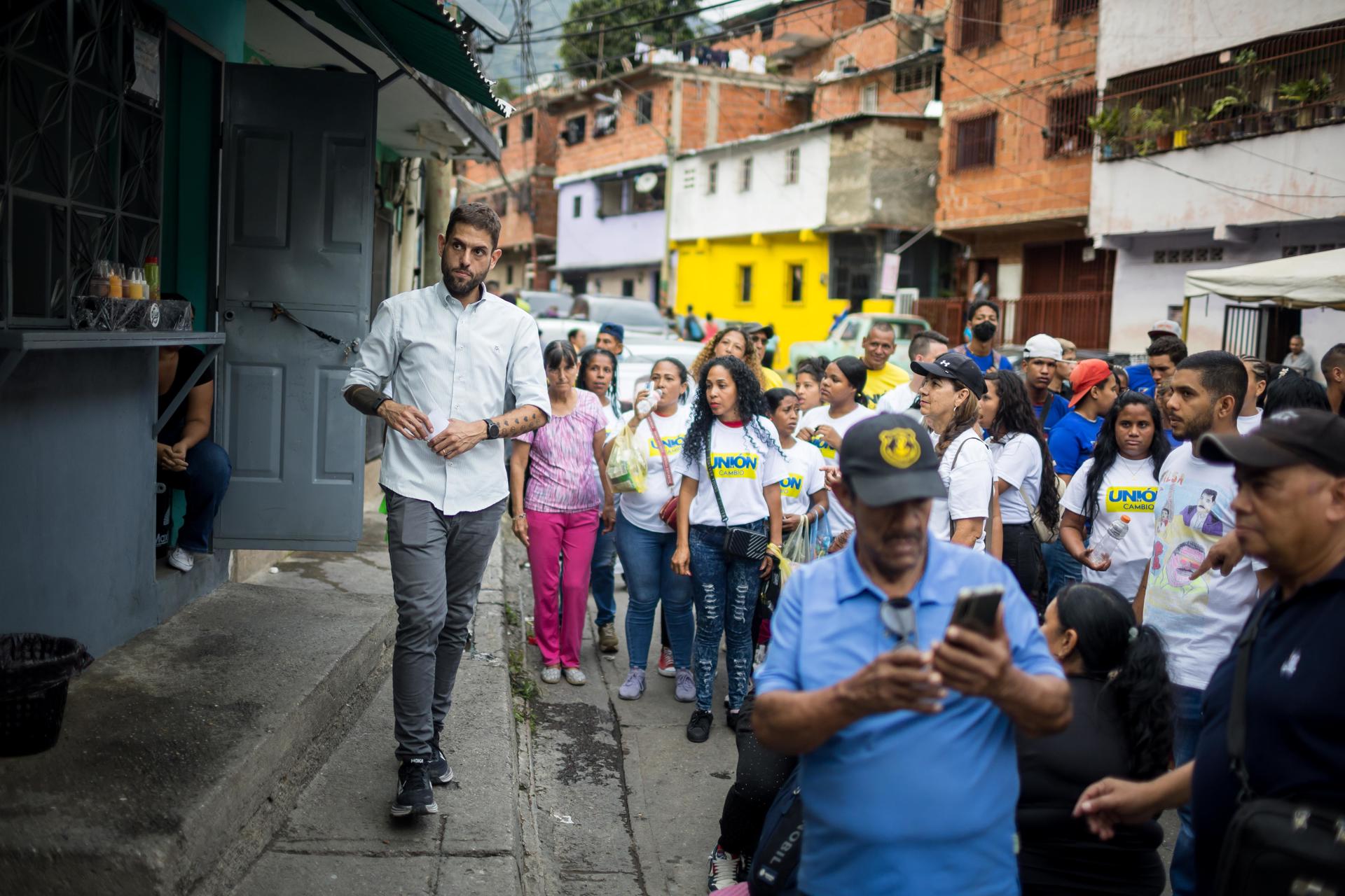 El exdiputado de Venezuela y aspirante a la Gobernación del estado Miranda, Juan Requesen (i), al caminar este viernes, 16 de mayo, durante un recorrido de campaña por el municipio Sucre del estado al que aspira gobernar. EFE/Miguel Gutiérrez