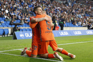 El delantero del Celta Alfon González (i) celebra con Sergio Carreira tras marcar ante la Real, durante el partido de la jornada 36 de LaLiga EA Sports que Real Sociedad y Celta de Vigo disputaron en el estadio Reale Arena, en San Sebastián. EFE/Juan Herrero