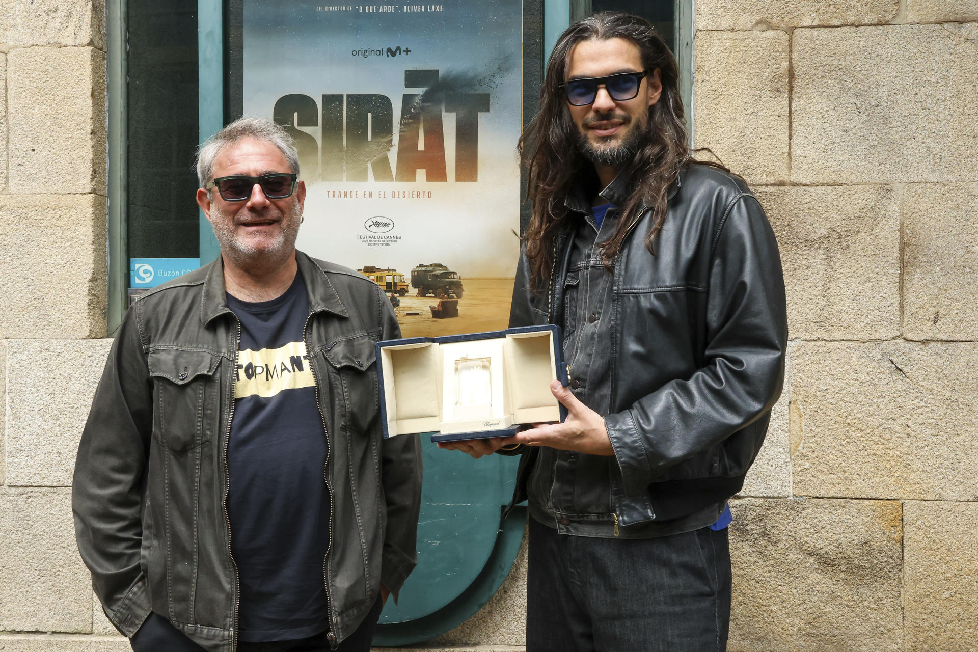 El cineasta Oliver Laxe (d) y el actor Sergi López, director y protagonista, respectivamente, de la película 'Sirat', que se alzó con el premio del Jurado en el último Festival de Cannes muestran el galardón este lunes en Santiago de Compostela. EFE/ Xoán Rey
