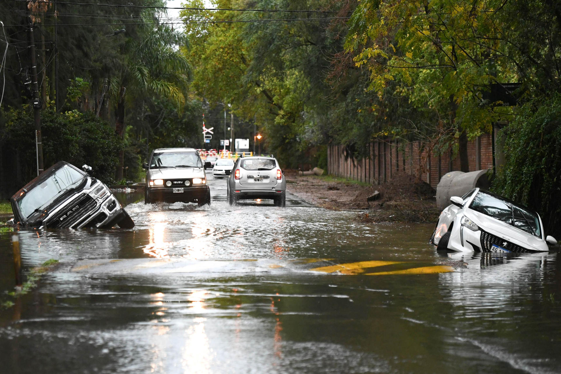 Fotografía de vehículos atrapados en medio de la vía por una inundación este sábado, en el barrio La Bota (Argentina). EFE/ STR

