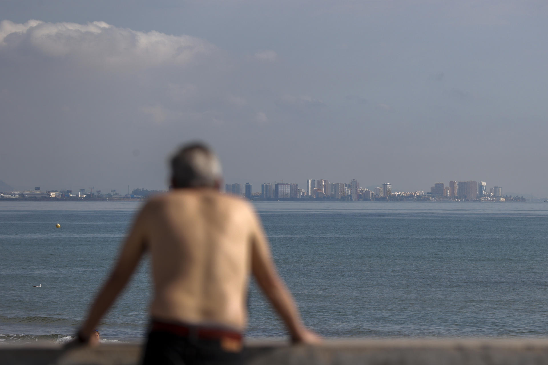 Un hombre contempla la playa de la Malvarrosa durante este martes en el que la Agencia Estatal de Meteorología (Aemet) ha establecido para la tarde el aviso amarillo en el interior de la Comunitat Valenciana por lluvias de 20 litros por metro cuadrado en una hora y tormentas con probabilidad de granizo pequeño. EFE/Manuel Bruque