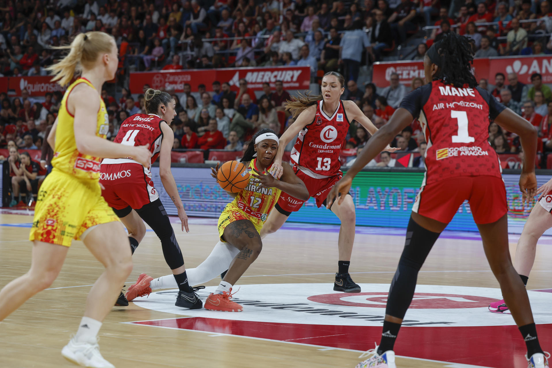 La jugadora del Spar Uni Girona Imani Tate (c) rodeada de rivales del Casademont Zaragoza, en el partido de la ida de las semifinales entre el Casademont Zaragoza y el Spar Uni Girona, este jueves en el pabellón Príncipe Felipe. EFE/ Javier Cebollada