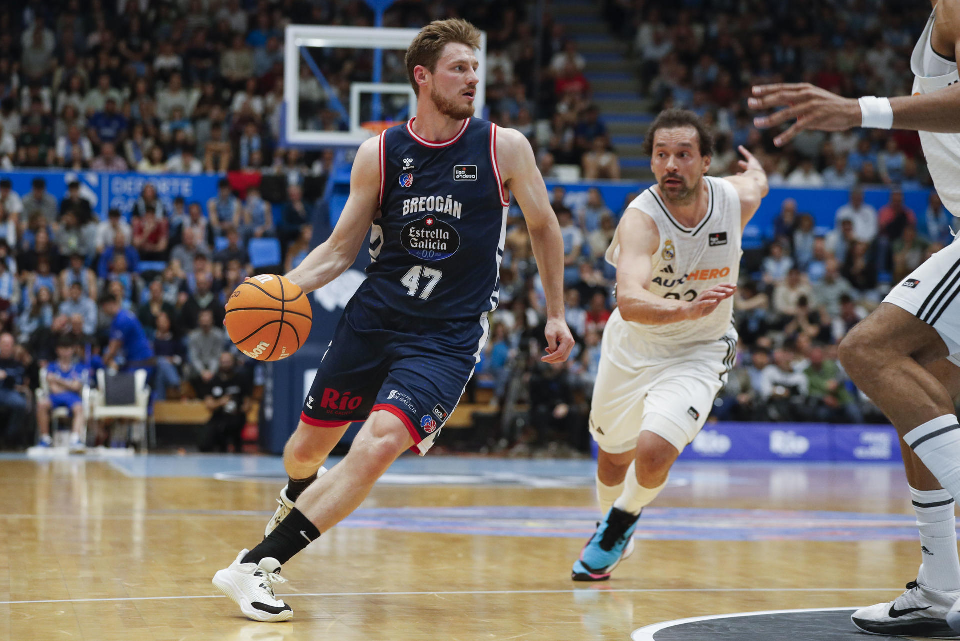 El jugador del Río Breogán A. Kurucs y el jugador del Real Madrid Sergio Llull, durante el partido de la jornada 31 de la Liga Endesa, este domingo en el Pazo Provincial Dos Deportes de Lugo.-EFE/ Pedro Eliseo Agrelo Trigo