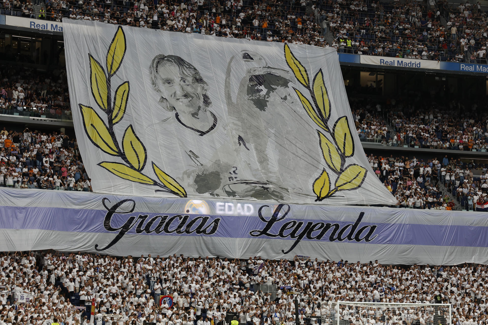 Aficionados del Real Madrid despliegan una pancarta en agradecimiento al centrocampista croata Luka Modrić antes del partido de la jornada 38 de LaLiga EA Sports entre Real Madrid y Real Sociedad celebrado este sábado en el estadio Santiago Bernabéu de Madrid. EFE/ J.J. Guillén