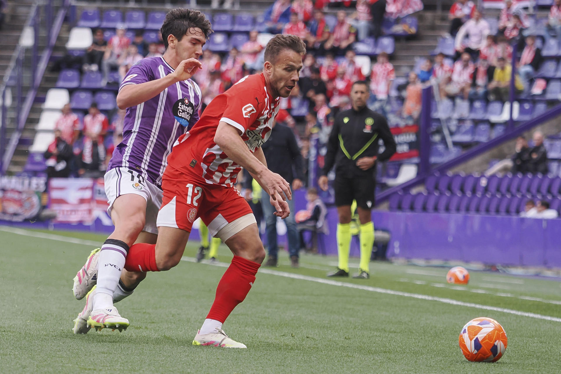 El centrocampista brasileño del Girona Arthur Melo (d), pelea un balón con el centrocampista del Valladolid Mario Martín durante el partido de LaLiga entre el Real Valladolid y el Girona, este martes en el estadio José Zorrilla. EFE/R. GARCIA.