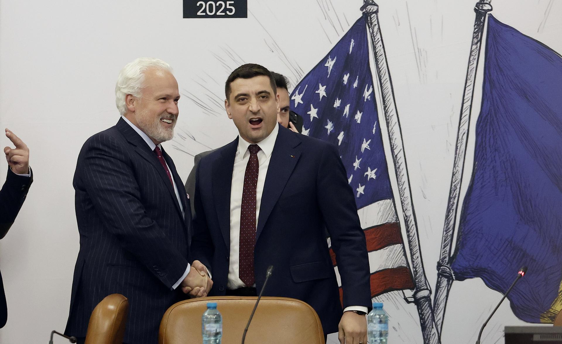 El líder del partido nacionalista AUR, George Simion (D), y el asesor político estadounidense Matthew Aaron Schlapp (I), presidente de la Conferencia de Acción Política Conservadora (CPAC), se dan la mano al llegar a la Conferencia Empresarial Rumano-Americana 2025 celebrada en el Palacio del Parlamento en Bucarest, Rumania, el 6 de mayo de 2025. El líder ultranacionalista del partido AUR, George Simion, ganó la primera ronda de la repetición de las elecciones rumanas con el 40,96 por ciento de los votos y se prepara para la segunda vuelta, que se celebrará el 18 de mayo, contra el alcalde de Bucarest, Nicusor Dan (no aparece en la foto). Tras el resultado de la primera ronda de las elecciones presidenciales, el primer ministro Ciolacu dimitió ayer. (Elecciones, Rumanía, Bucarest) EFE/EPA/ROBERT GHEMENT