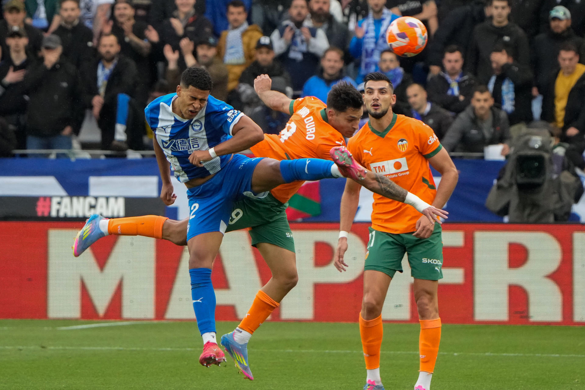 El defensa uruguayo del Alavés Santiago Mouriño (i) pelea un balón ante el delantero del Valencia Hugo Duro (c) durante el partido de la jornada 36 de LaLiga EA Sports, entre el Deportivo Alavés y el Valencia CF, celebrado este miércoles, en el estadio de Mendízorrotza, en Vitoria. EFE/ Adrian Ruiz Hierro