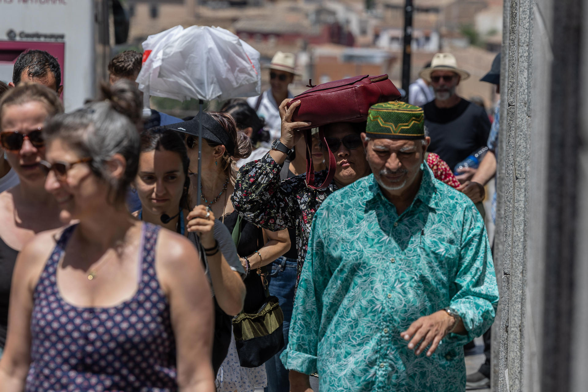Toledanos y turistas se protegen del calor buscando sombras y bebiendo por las calles de Toledo. EFE/Ismael Herrero