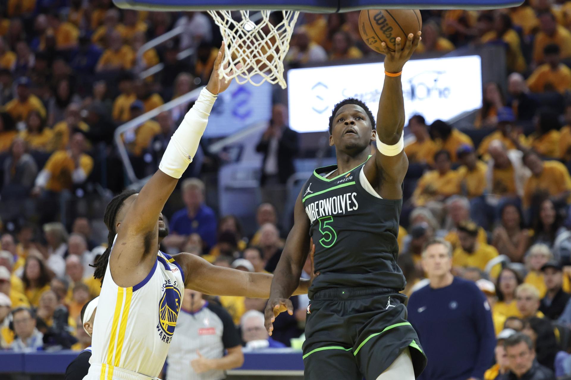 Anthony Edwards (d) de los Minnesota Timberwolves va a la cesta con la marca de Kevon Looney (i) de los Golden State Warriors. EFE/JOHN G. MABANGLO