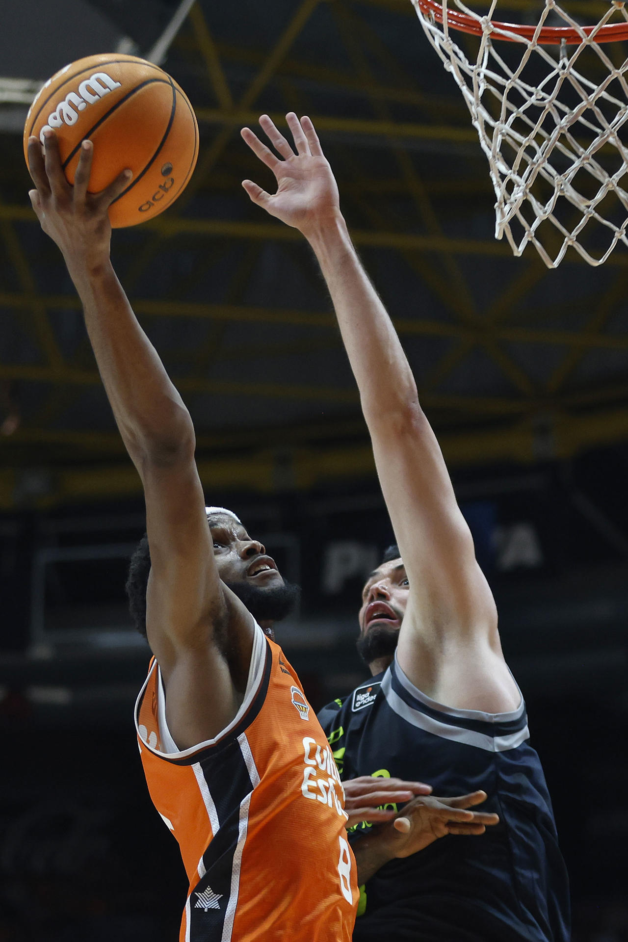 El jugador del Valencia Basket Jean Montero y el jugador del Dreamland Gran Canaria Pierre Pelos, durante el partido de la Lida Endesa de la Jornada 31 disputado en el pabellón de la Fuente San Luis de Valencia.- EFE/Miguel Ángel Polo.