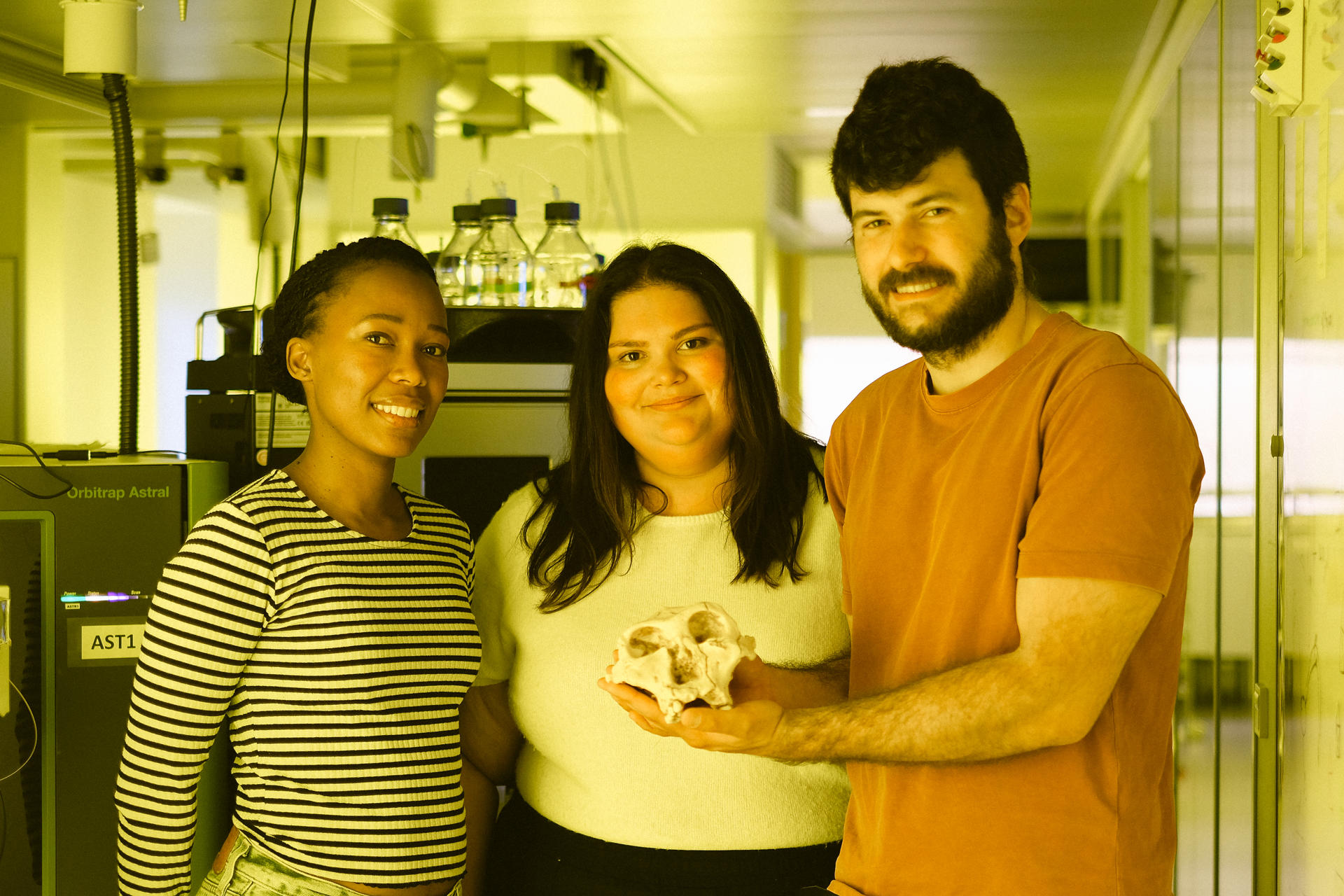 Las tres autoras y autores principales del artículo con una réplica de Paranthropus robustus SK 48: la Dra. Palesa P. Madupe, la Dra. Claire Koenig y el Dr. Ioannis Patramanis. Crédito: Victor Yan Kin Lee.