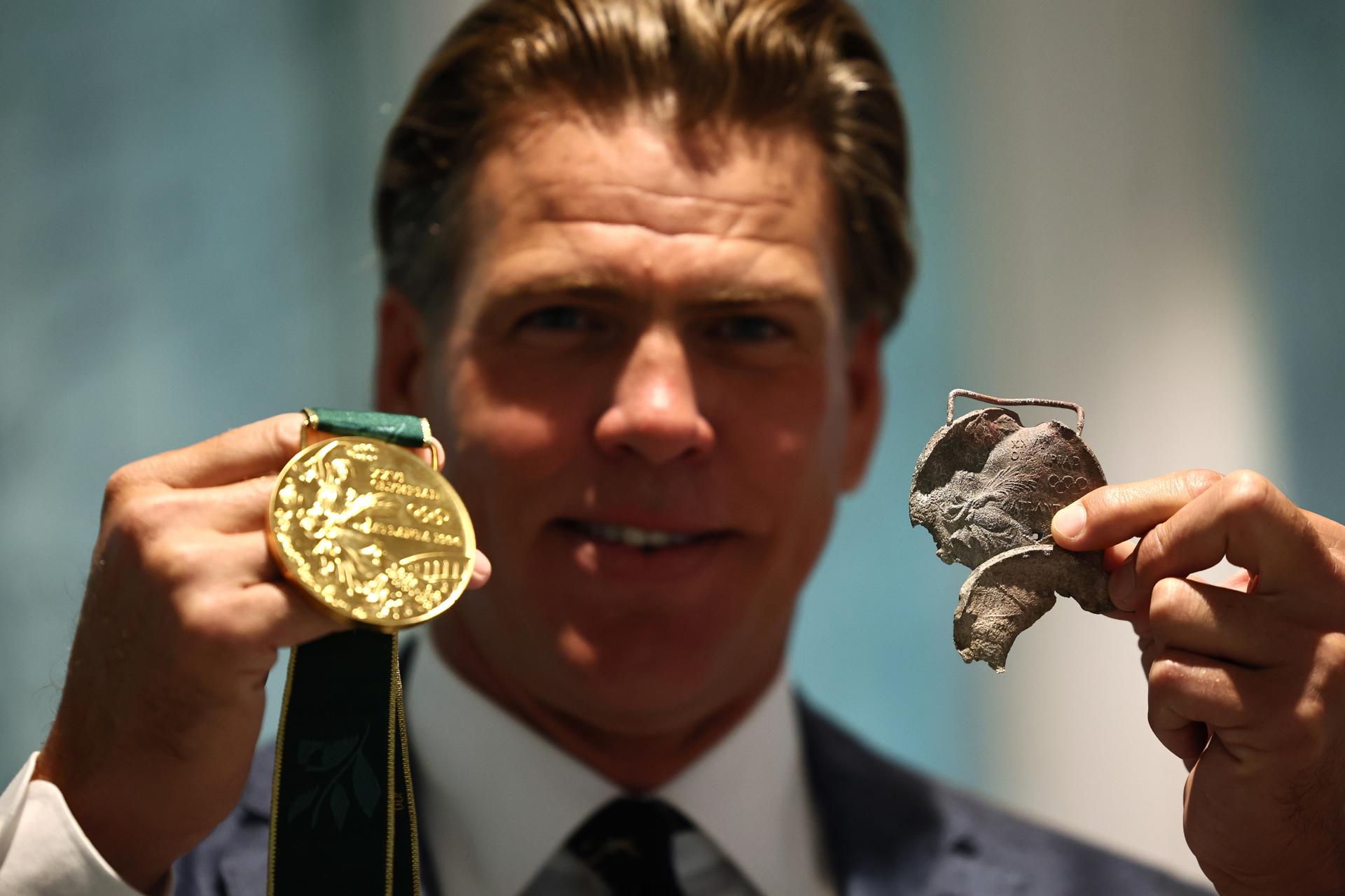 El nadador estadounidense Gary Hall Jr. sostiene una medalla de oro original de Atlanta 1996 que se derritió durante los incendios forestales en Los Ángeles que destruyeron su casa a principios de este año y la réplica de la medalla de oro que el presidente del COI, Thomas Bach, le entregó durante una ceremonia en la Casa Olímpica en Lausana, Suiza, el 05 de mayo de 2025. (Suiza) EFE/EPA/Denis Balibouse / POOL POOL, USO EDITORIAL SOLAMENTE