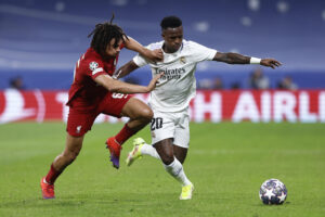 El delantero del Real Madrid Vinicius Junior (d) pelea un balón con Trent Alexander-Arnold, del Liverpool, durante el partido de vuelta de los octavos de final de la Liga de Campeones, el 15 de marzo de 2023. EFE/Rodrigo Jiménez