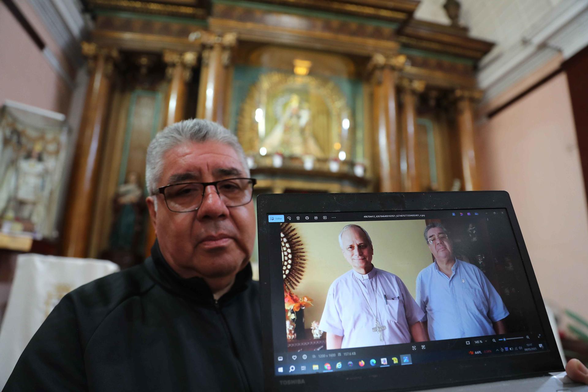 El sacerdote José del Rosario, de la basílica Nuestra Señora del Carmen, muestra una foto con el entonces administrador apostólico de la Diócesis del Callao, Robert Prevost, este jueves durante una entrevista con EFE en Lima (Perú). EFE/ Paolo Aguilar